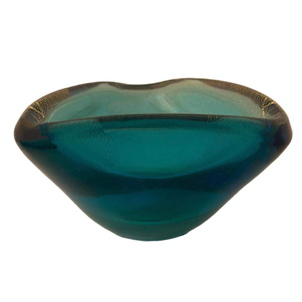Hand-crafted by skilled artisans of Murano, this three-sided glass dish showcases the vibrant colors and intricate detail that characterize the island's tradition of glassmaking. An exquisite deep Turquoise color with swirls of shimmering gold leaf,