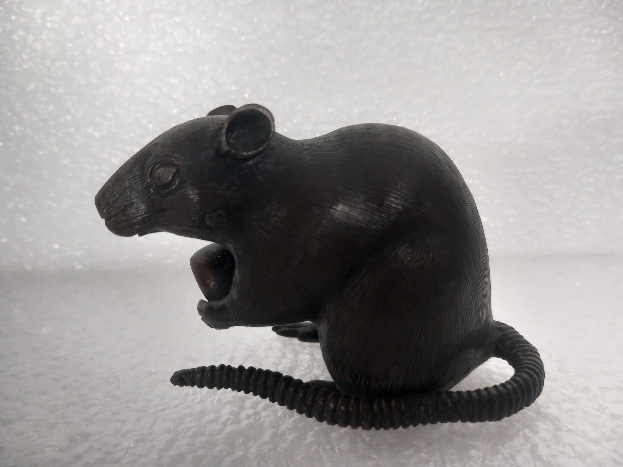 Three small Japanese bronze rats, Meiji Period, two holding chestnuts, each signed, approximately 9cm long and largest 6.5cm high and another small model of a rat, 9.5cm long 
