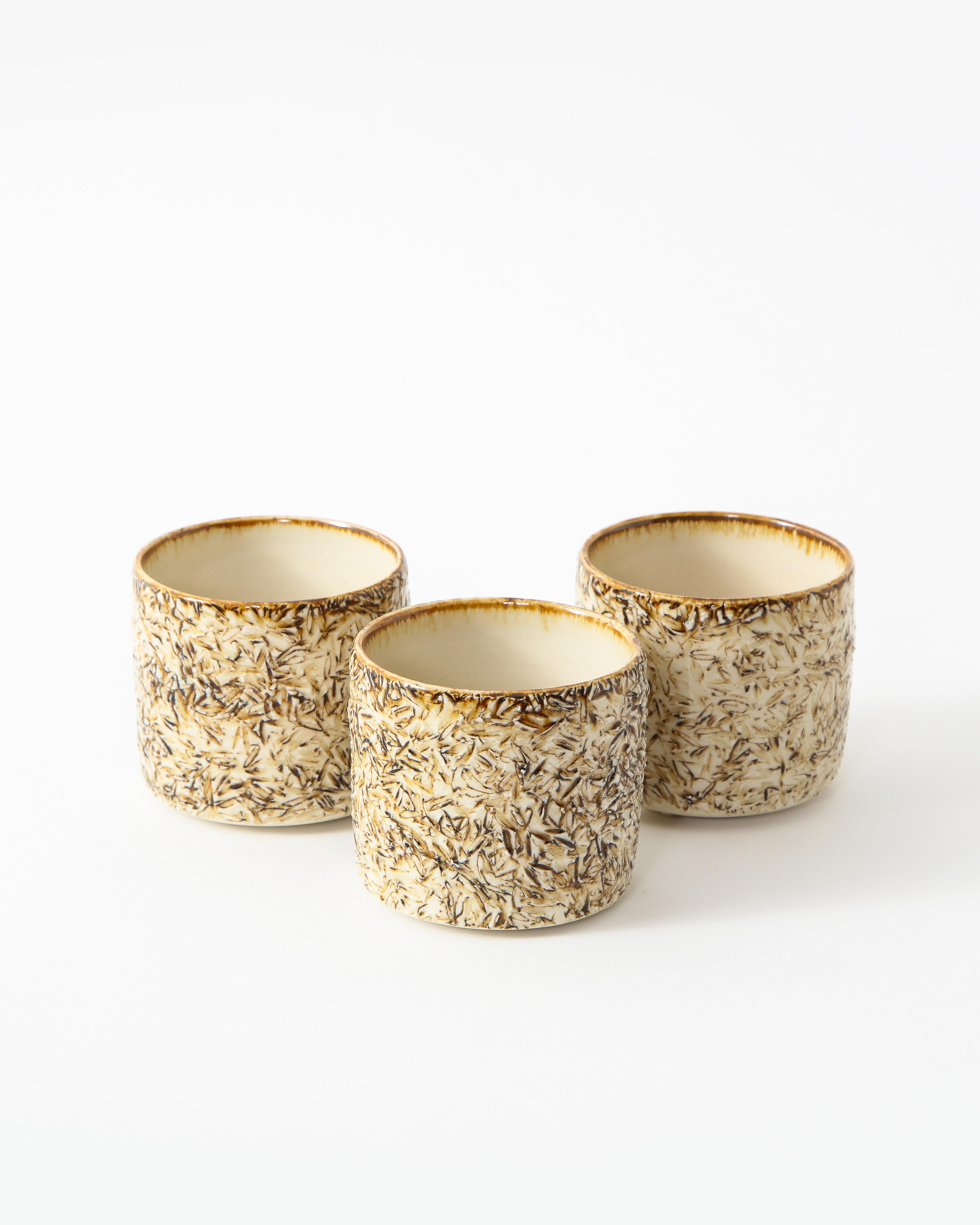 Three small neutral toned textured ceramic tea tumblers. Contemporary.