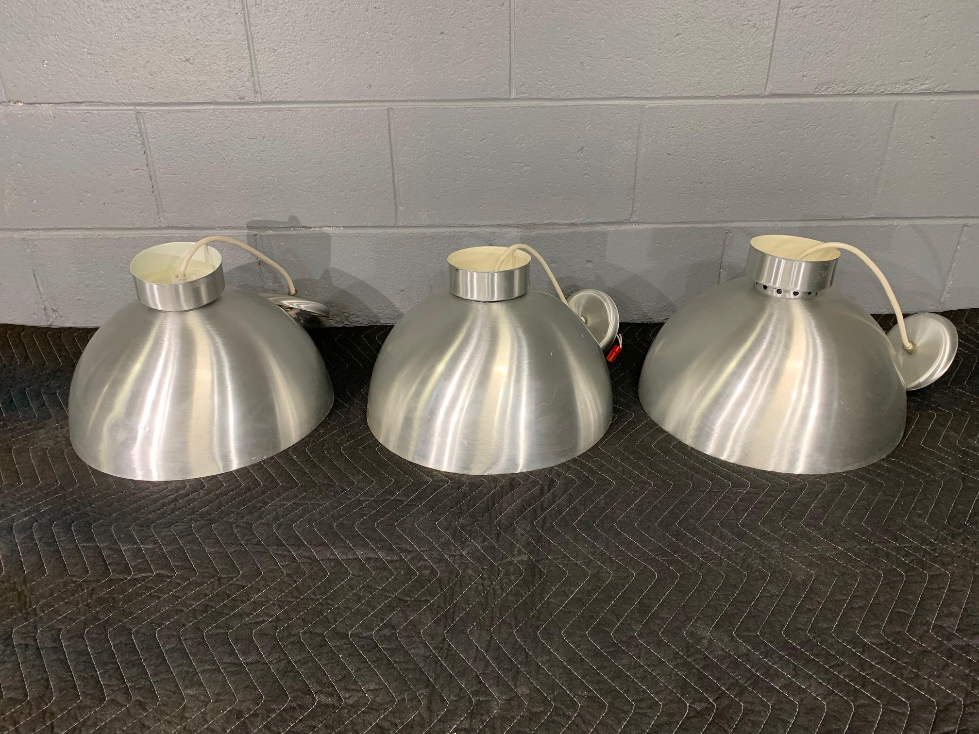Three spun aluminum midcentury style round hanging lights. Would be a superb addition to any Mid-Century Modern decor.