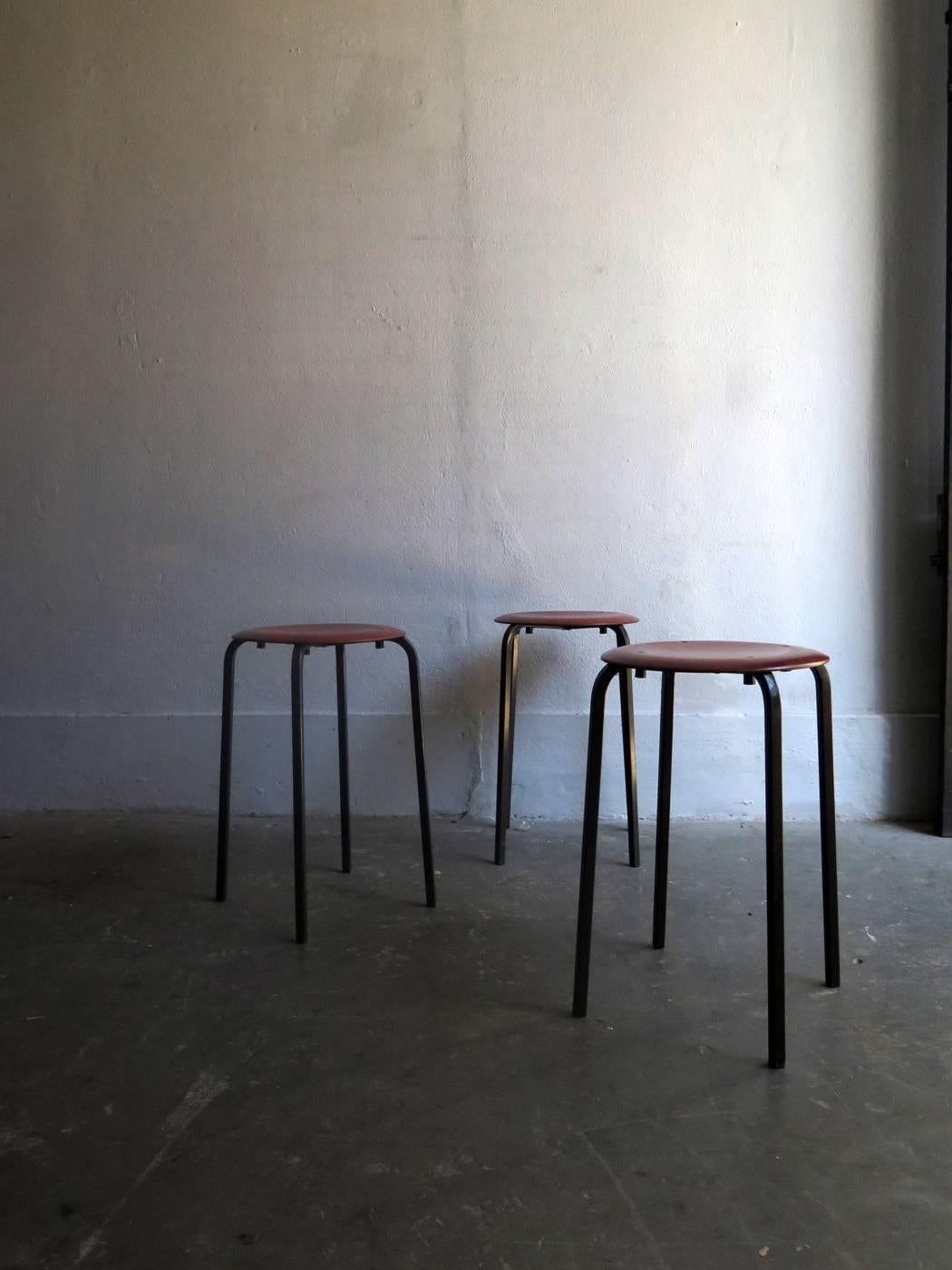 Three stackable elegant stools with molded plywood and rosewood venner seat.