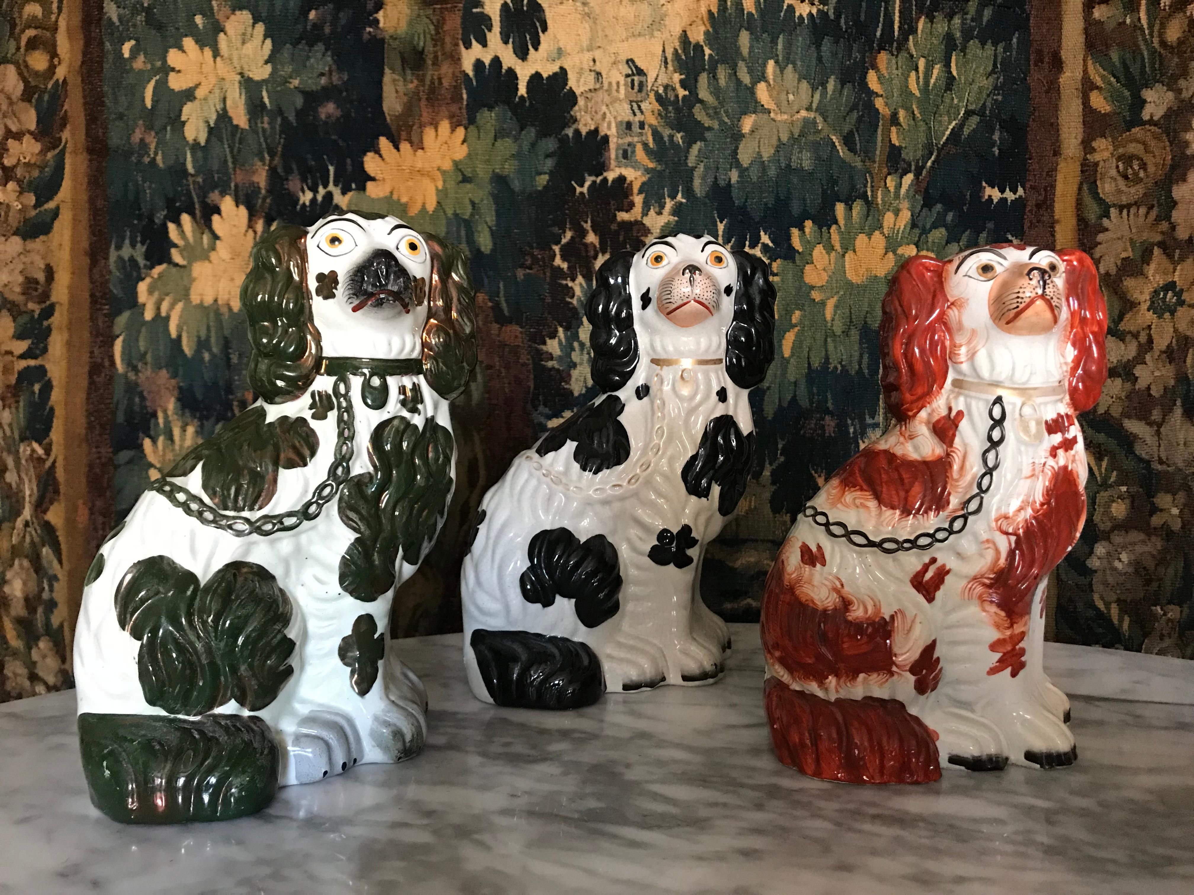 Three Staffordshire Dogs*; a very decorative set, each with different color spots and gilded details, as well as numbering beneath (two marked 2 & one dog marked 3;  see images) 
One black and white dog, one dark green and white and one brownish-red