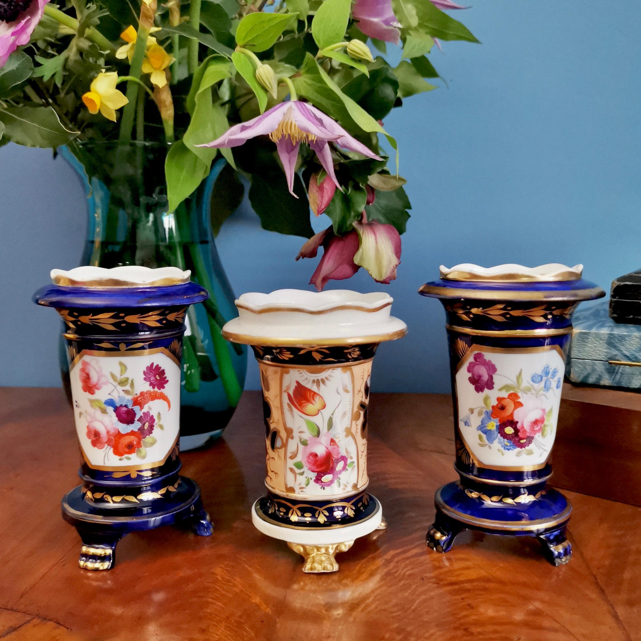 This is a set of three little spill vases made by an unknown Staffordshire maker in circa 1820, which was the Regency era. Two of the vases are cobalt blue, one is salmon, and all three have beautiful gilding and hand painted flowers.

Spill vases