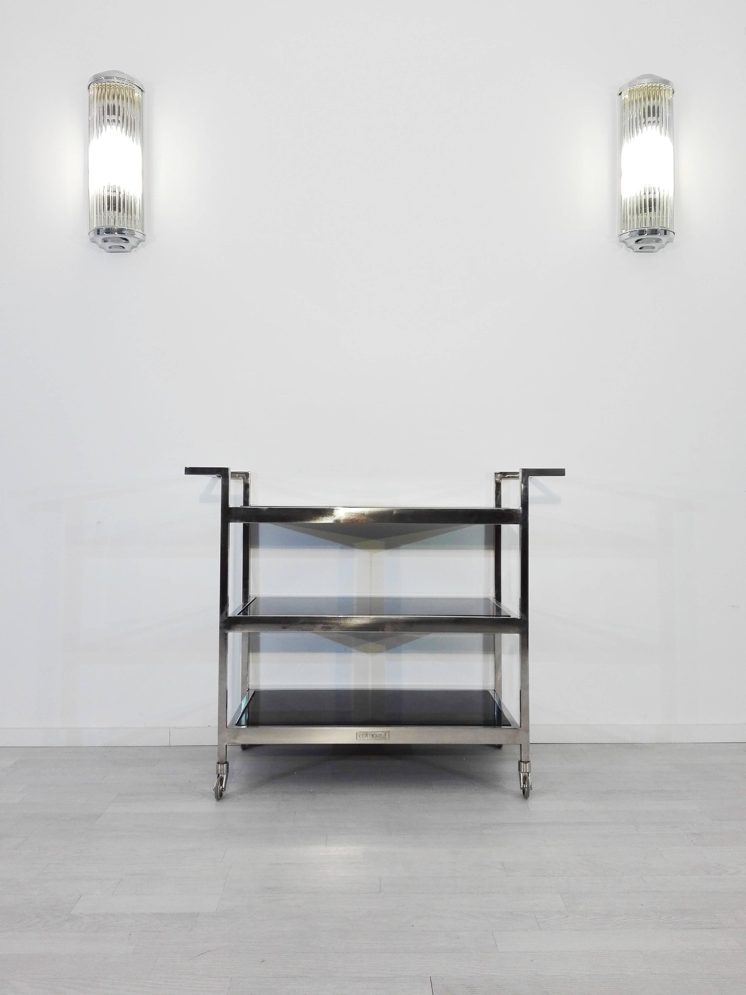 Three staged Bauhaus design bar- or serving table with a wonderful design and chrome handles on both sides. With a frame made of high quality, polychromed brass and three serving stages made of black lacobel glass.

 Unique Bauhaus design with