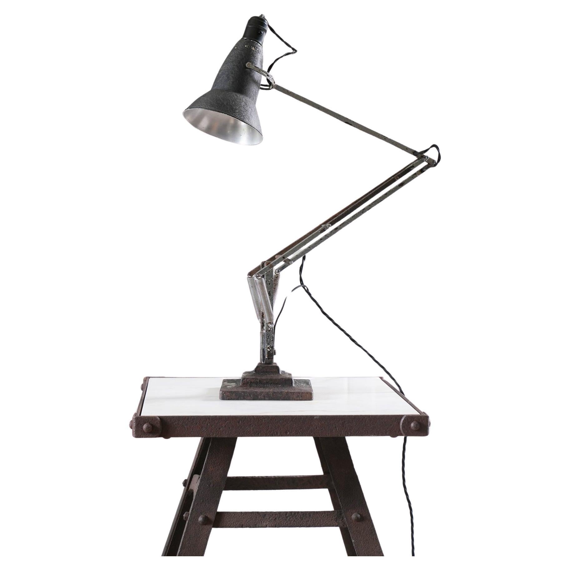 An early three step, model 1227 Anglepoise desk lamp.

Produced between 1935 and 1938, identified by the cast iron three step base with it's crinkle or japanned painted finish, steel arms, perforated and narrower shade and large earthing bolt to the