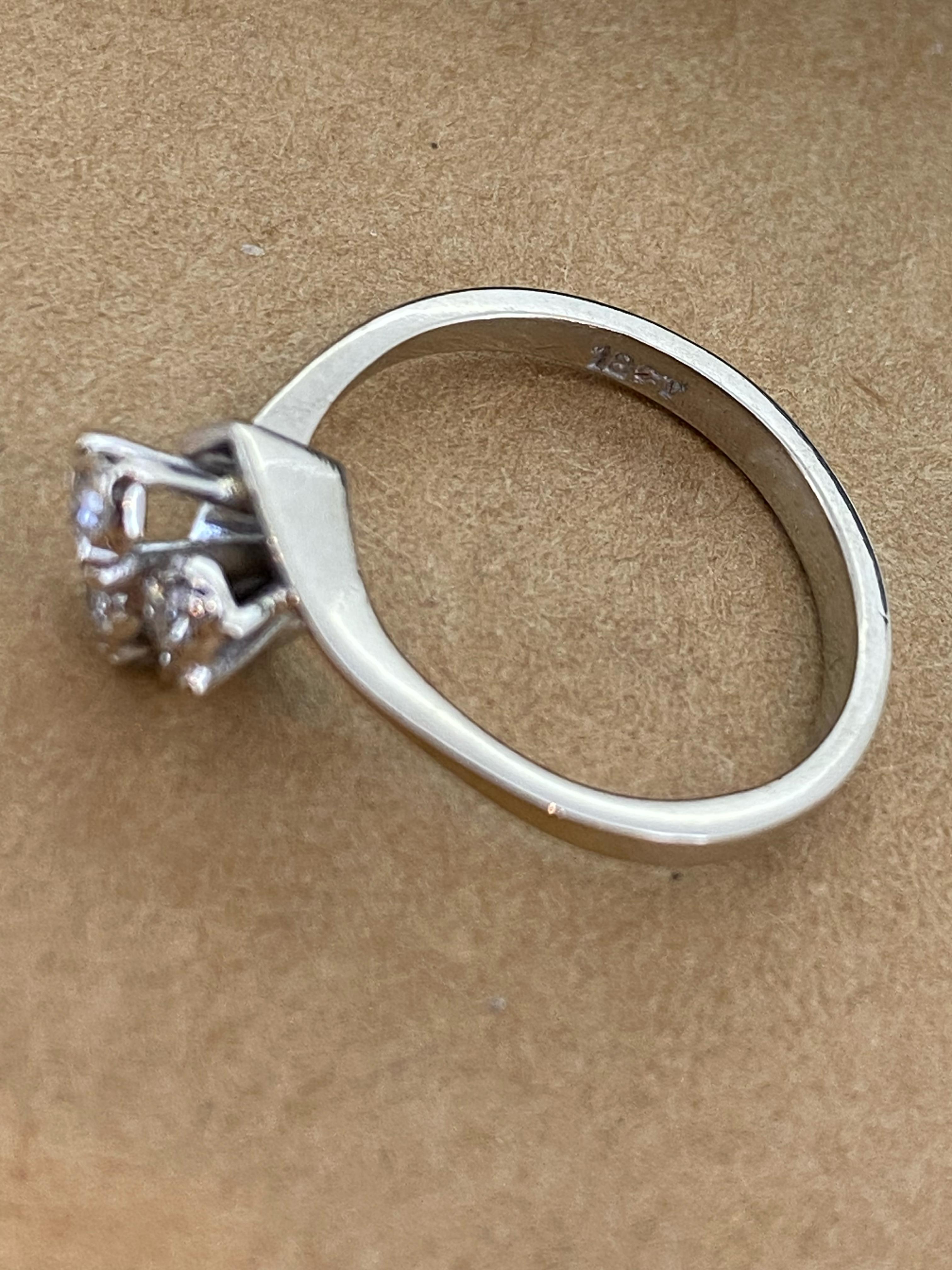 This exquisite engagement ring is handmade & 
a very typical retro 1950’s piece of jewellery 

Crafted in 18K White Gold &
designed as a flowerhead, 
centering 3 rose cut diamonds,
claw-set, of 0.10ct each, 
of H colour, VS clarity 
Total diamonds'