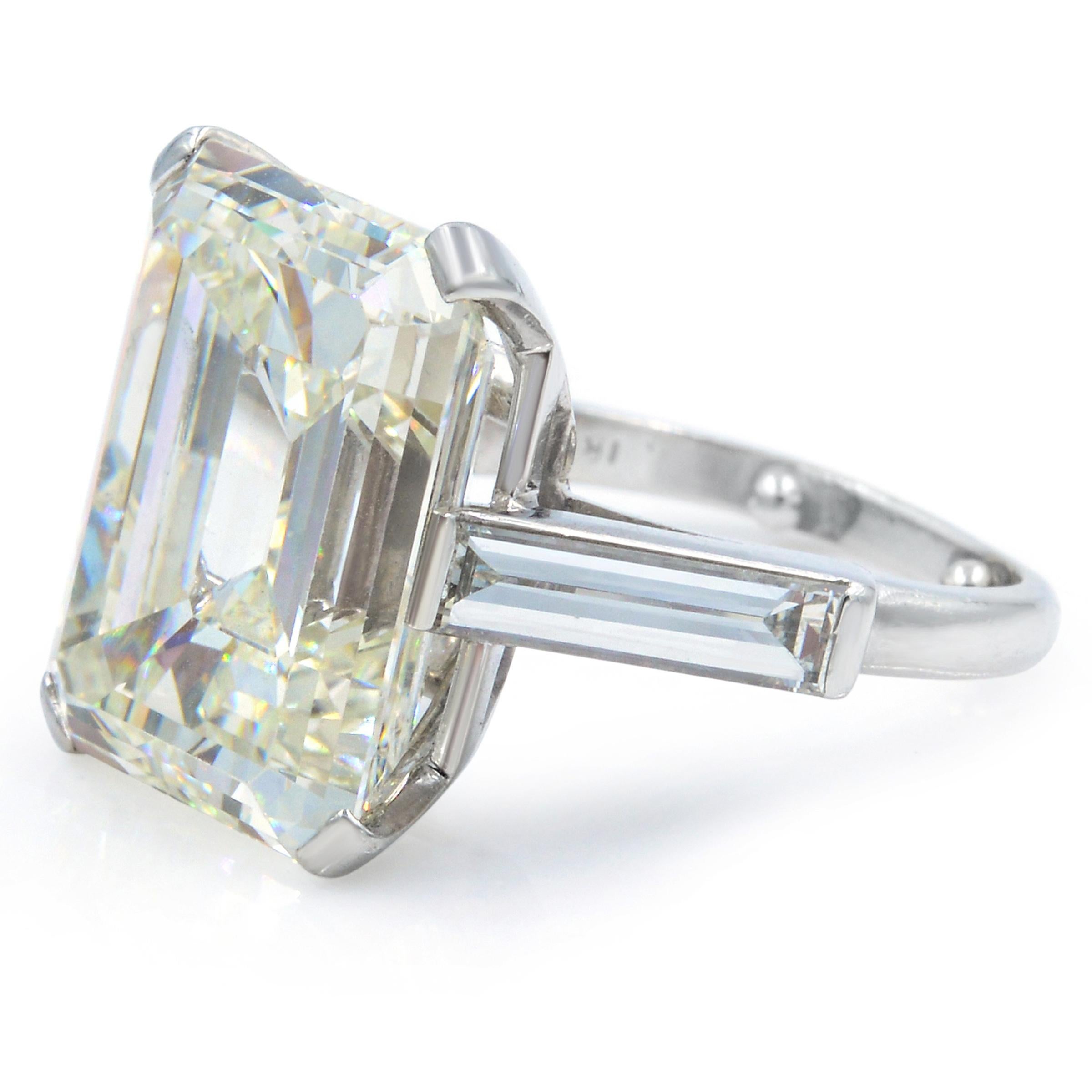 Impressive in both quality and scale, this true Art Deco engagement ring features a stunning Emerald Cut diamond of 11.27 in carats, accompanied with a GIA grading report indicating K color and VS1 clarity. The spectacular diamond is traditionally