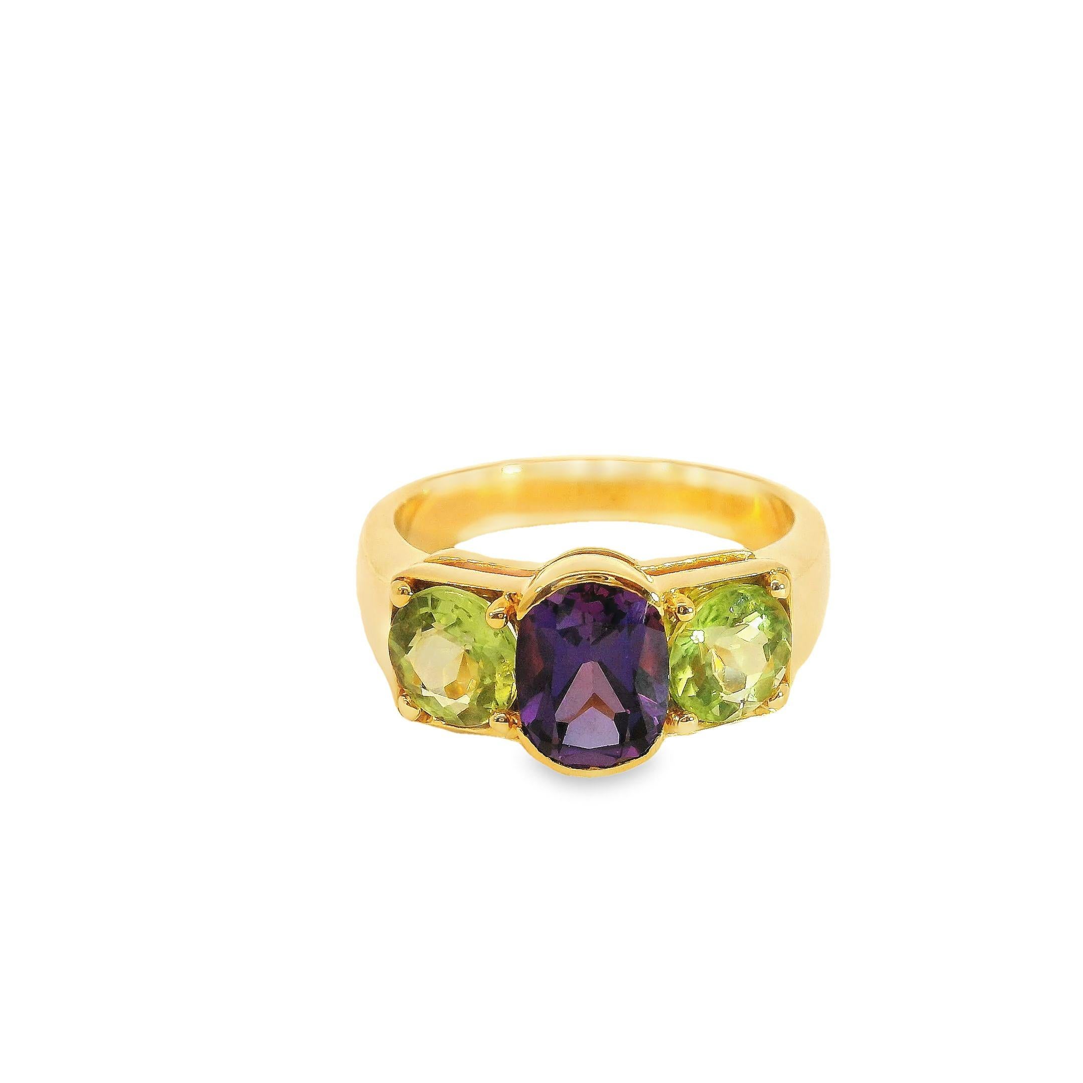 This striking ring dazzles with its blend of hues and textures. At its heart rests a regal oval-cut amethyst weighing over one carat, its rich purple evoking nobility. On either side sit matching oval peridots totaling just under two carats, their