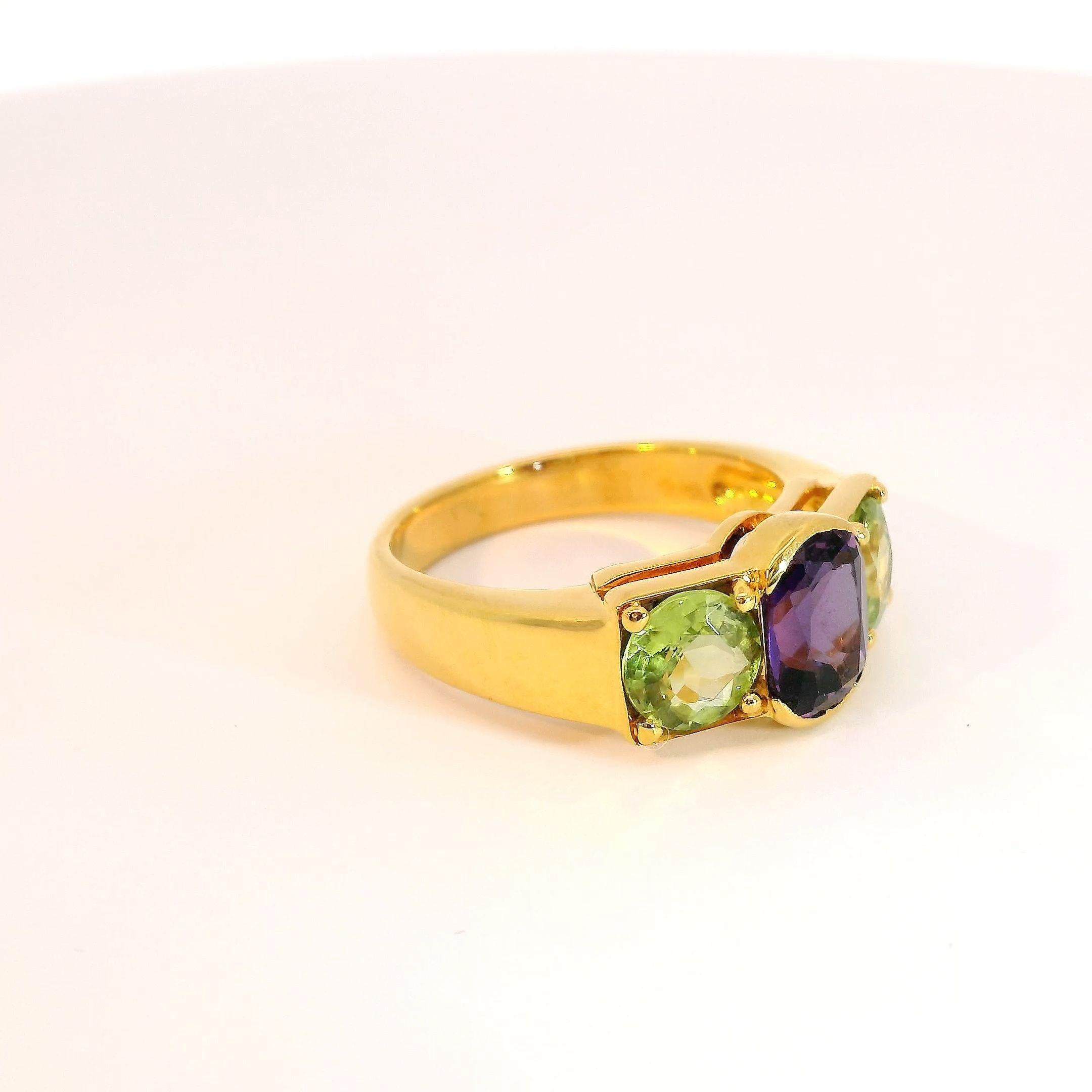 Oval Cut Three-stone 1.45 carat Oval Amethyst and Round Peridot Ring in 18K Yellow Gold For Sale