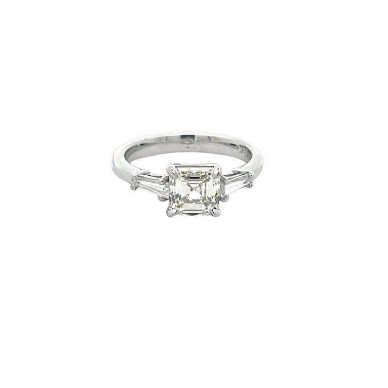 Get ready to be blown away by the breathtaking beauty of this three-stone ring! Featuring a stunning Asscher-shaped white diamond, this ring boasts a center stone weighing an impressive 1.70 carats. Accompanying the Asscher, are two exquisite