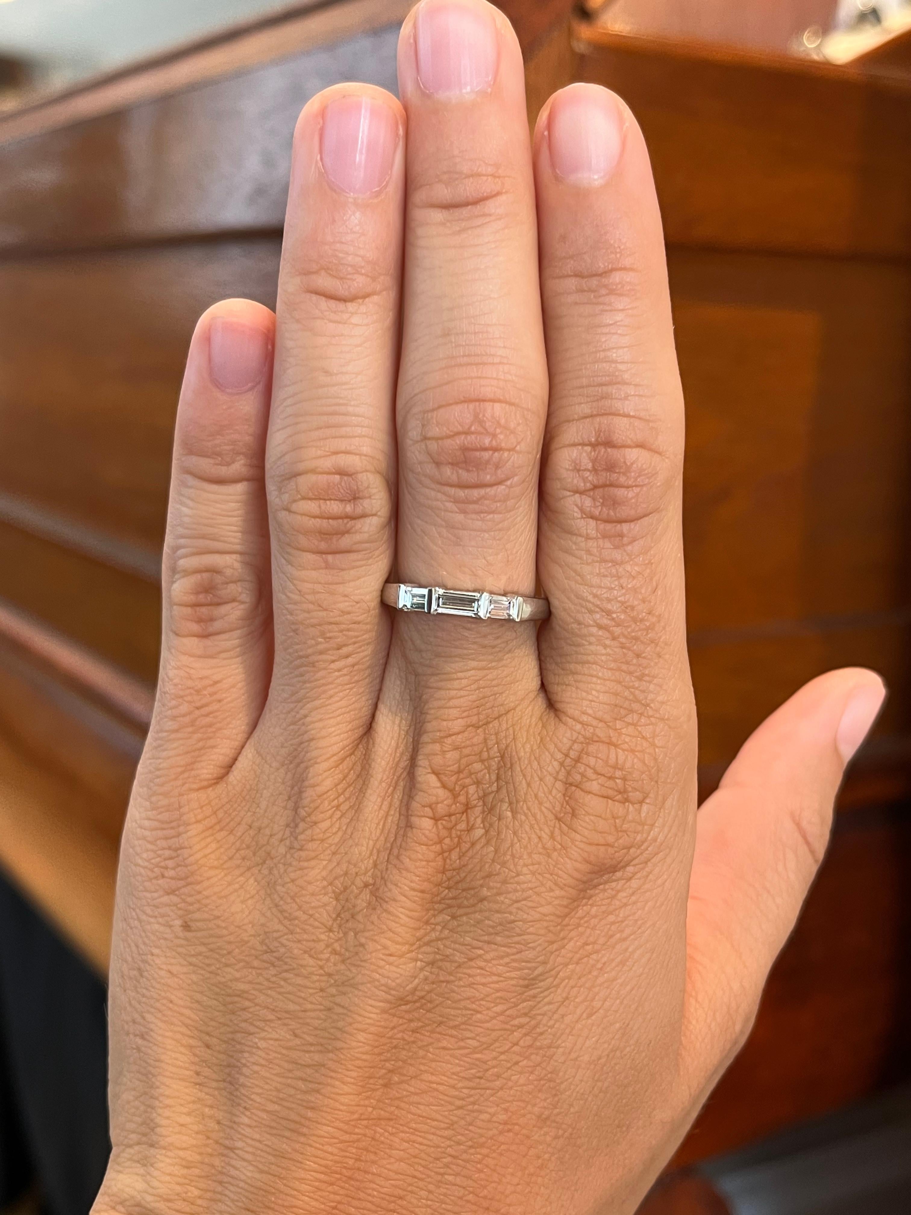 Crafted by Bracken Jewelers in Santa Monica, California. Three baguette cut diamonds are bar-set sideways on the top of this platinum wedding band. The center stone is largest with slightly smaller accents on each side.

- 3 baguette cut natural