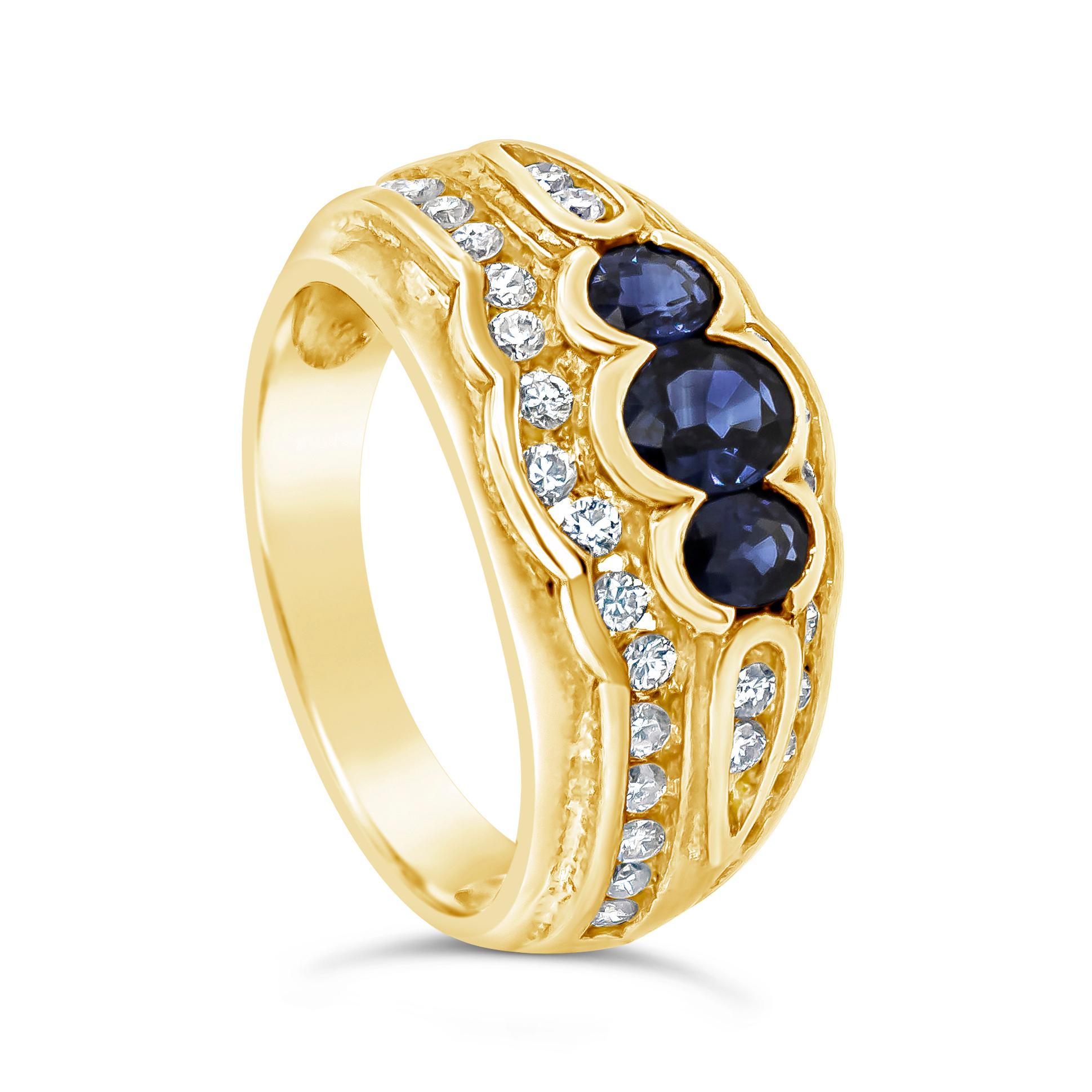 A gorgeous and fashionable 18 karat yellow gold ring showcasing three oval cut blue sapphires, accented by round brilliant diamonds. Sapphires weigh 0.80 carats total; diamonds weigh 0.40 carats total. 