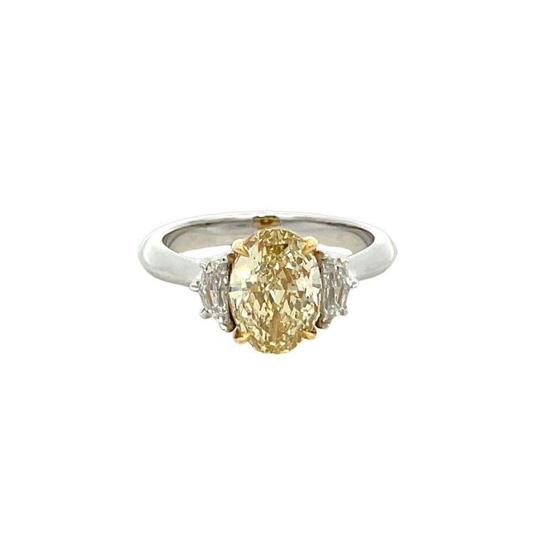 Prepare to be amazed by the stunning beauty of this three-stone ring! It showcases a breathtaking oval-shaped brown-yellow diamond in the most exquisite color for this diamond. The ring's centerpiece is a remarkable 2.05-carat stone, complemented by