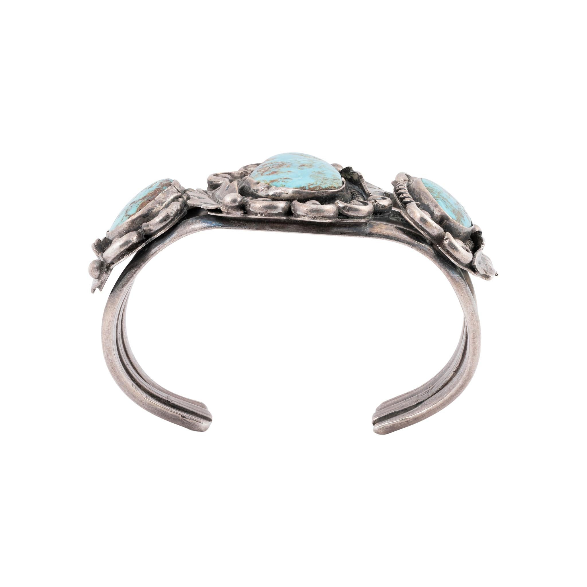 Bracciale in turchese Cerrillos e argento sterling. Bracciale molto robusto con tre pietre turchesi in rilievo incastonate in un bordo di corda intrecciata. Ciascuna pietra ha dettagli di piume, smerli e perline in argento ed è fissata a un