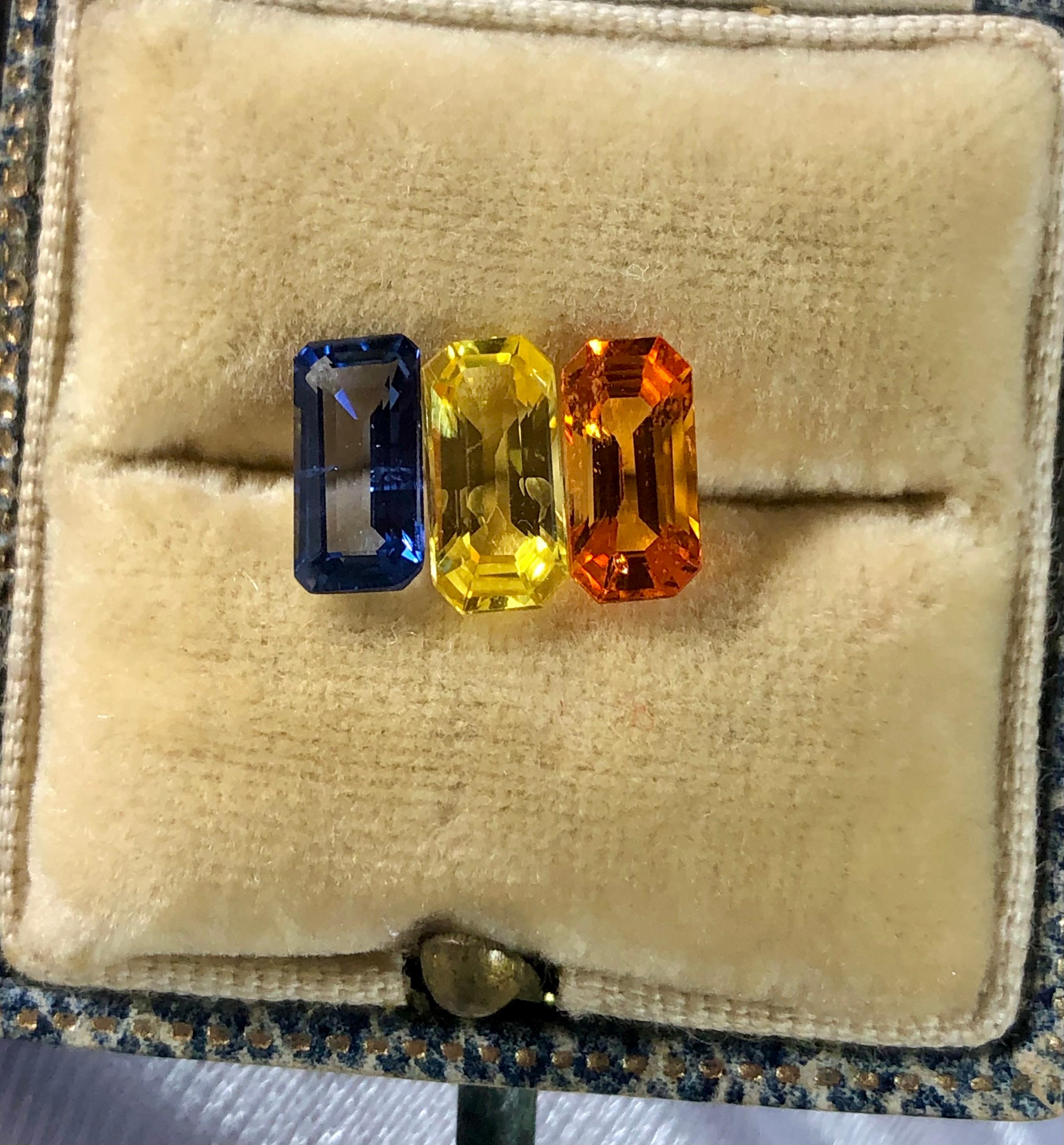 Multicolor Three stone Ceylon sapphires high-quality emerald cut.  Yellow sapphire 1.12 carats, Orange vibrant 1.09 carats, and blue sapphires weighing 0.98 carats.  **these incredible gemstones are available to purchase as loose stones or