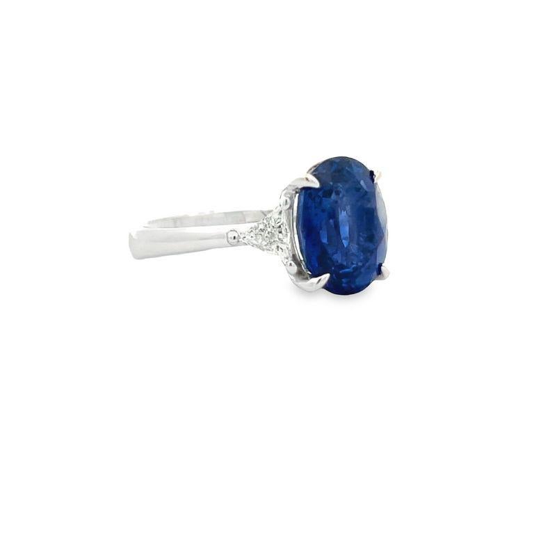 Get ready to be blown away by the breathtaking beauty of this three-stone ring! Featuring a stunning oval-shaped Ceylon sapphire in the finest color for this gemstone, this ring boasts a center stone weighing an impressive 6.46 carats. Accompanying