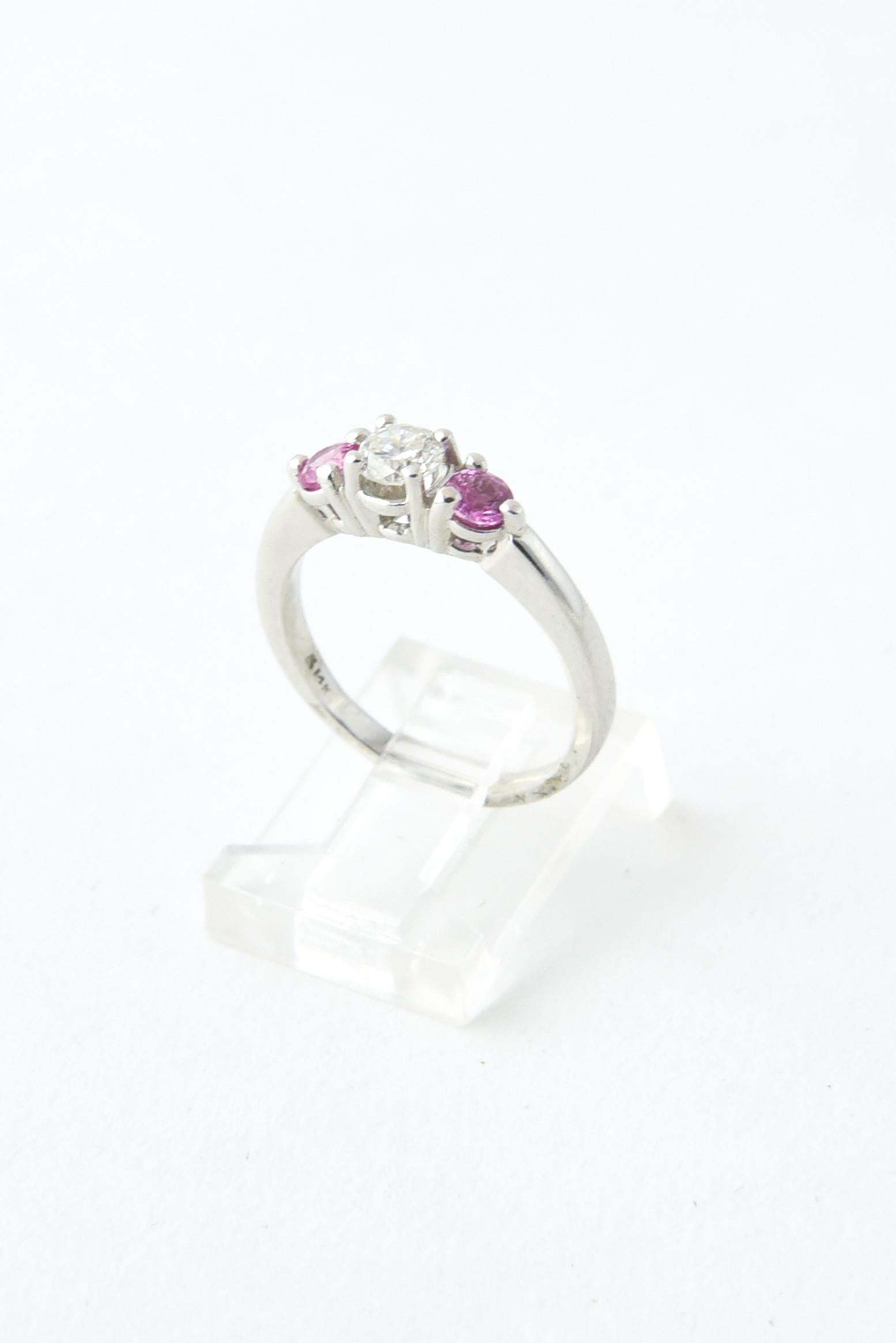 Vintage 14K white gold ring presenting a prong-set 0.50 carat diamond mounted between two 0.20 carat pink sapphires. 
US size: 6.75; can be resized.