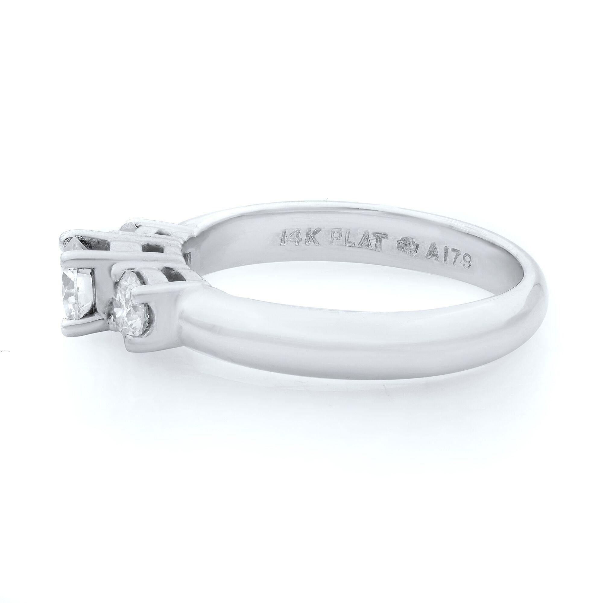 Simple three-stone round cut diamond engagement ring in 14k white gold and platinum. Diamonds are totaling 0.75 carats. The three stones are VS1 clarity and H color.  The ring size is 7.25. Comes in our presentation box. 
