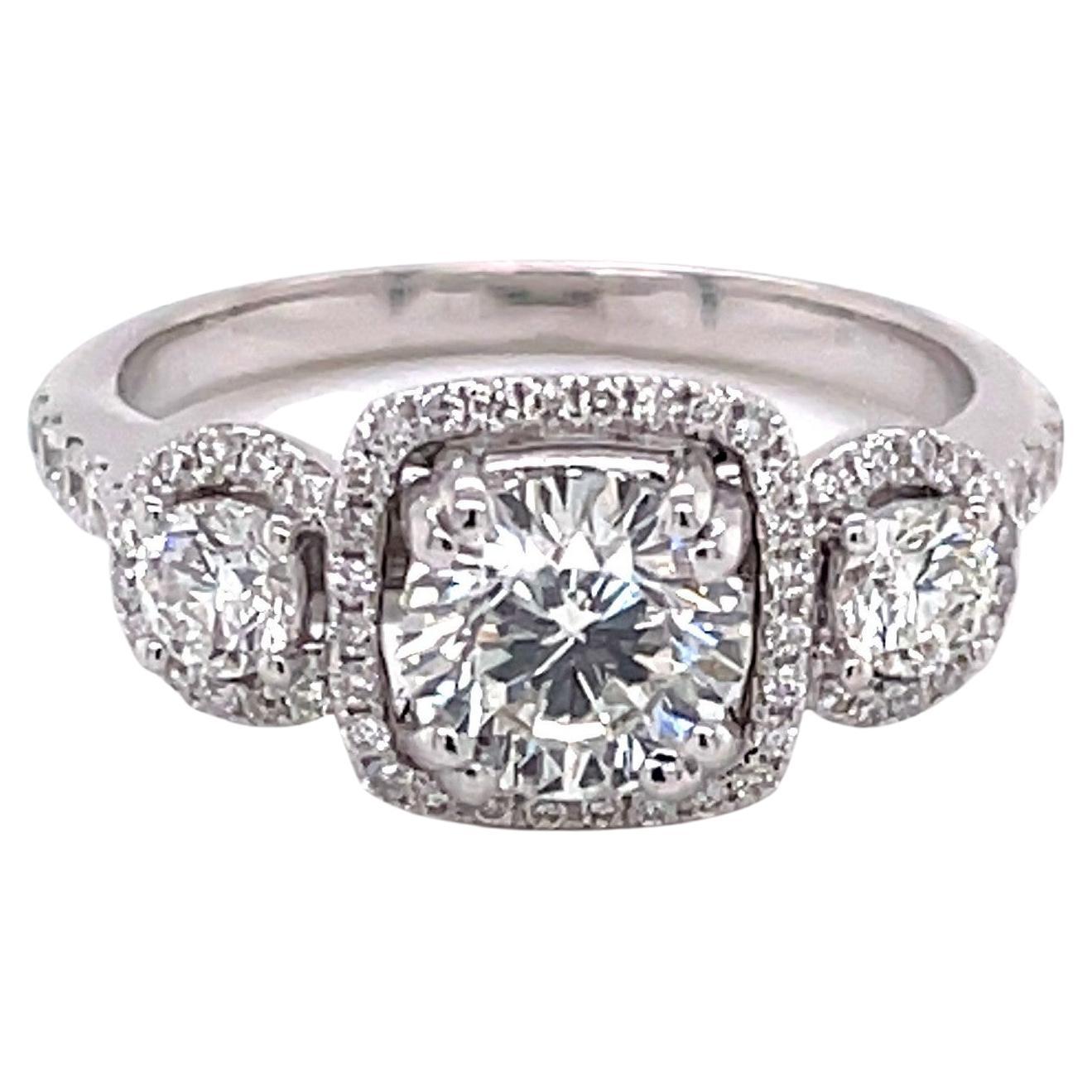 With a total diamond carat weight of over 1.5 carats, this elegant ring has enormous sparkle and light. Prominent on the raised gallery of this ring, each of the three full cut round diamonds; left .42 carat H/VS / center .61 carat  H/I2 / right .52