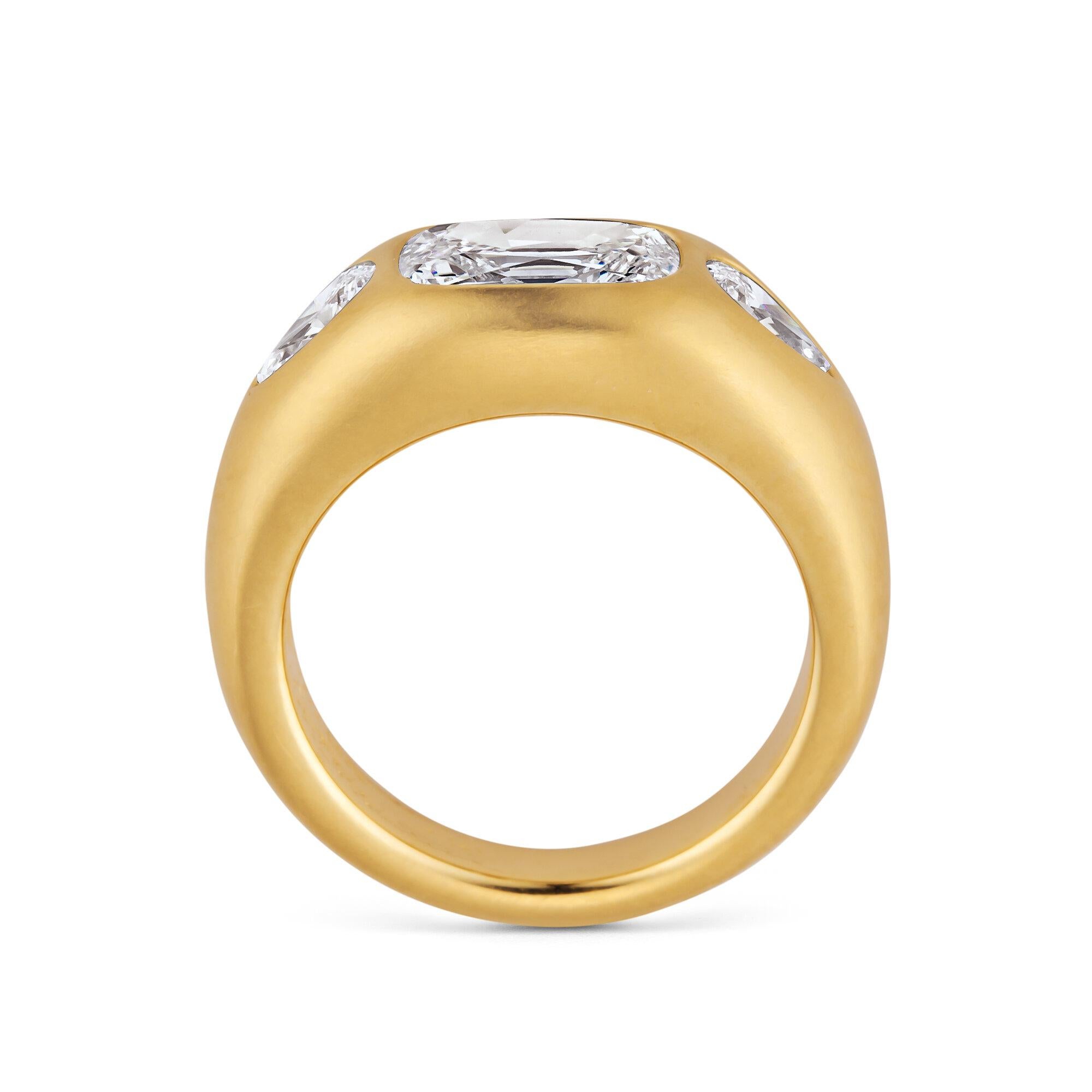 A 1.31 carat elongated cushion brilliant cut center set diamond, flanked by two pear shape diamonds, are sculpturally mounted in 18 karat matte finished yellow gold creating an architecturally modern gypsy style ring.  Center stone color F.  SI2