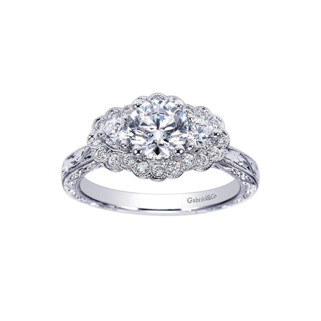 Three Stone 14k White Gold Diamond Engagement Ring by Gabriel Co. Exquisite bezel halo design combined with milgrain finish give this ring a romantic, vintage look. Center diamond is GIA certified, 0.54 ct weight, H color, VS clarity. Side diamonds