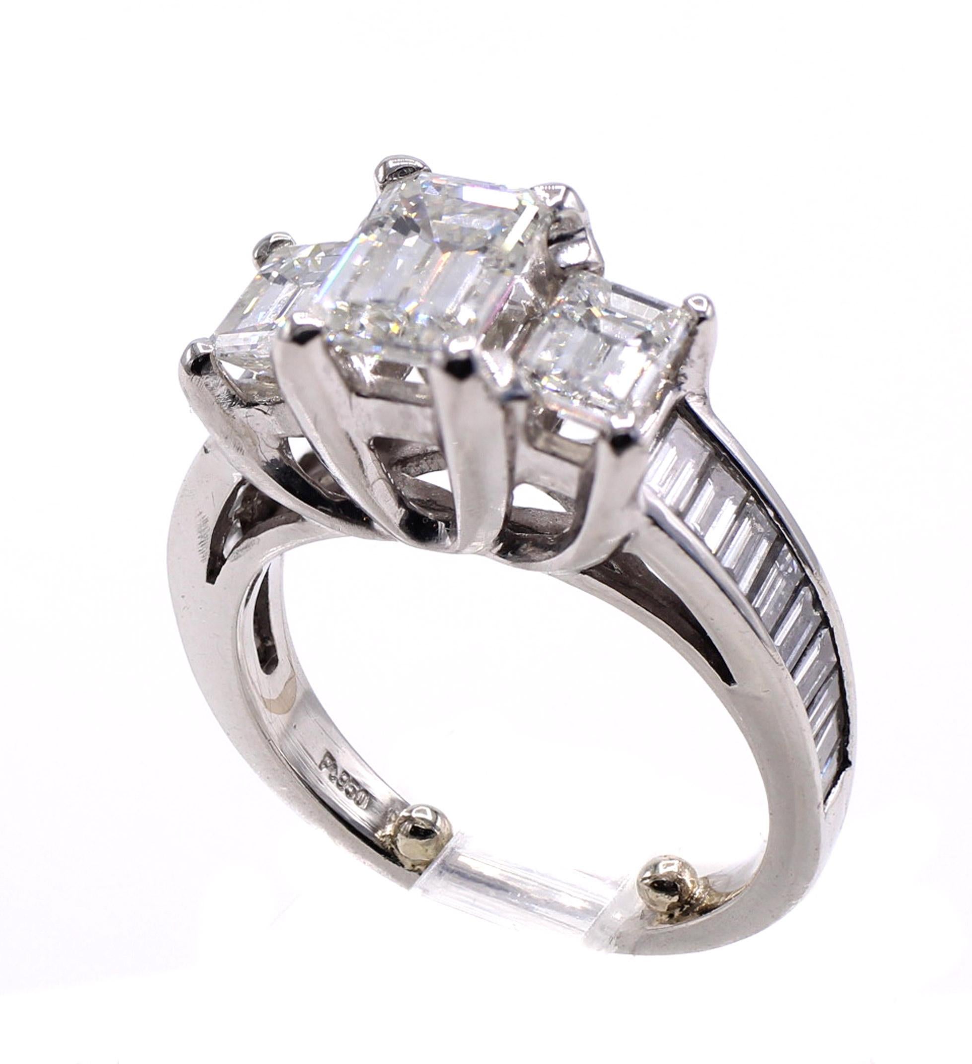 Beautifully designed and masterfully handcrafted this platinum 3 stone diamond ring features a perfectly proportioned emerald cut diamond weighing 1.12 carats. Flanked on each shoulder by 2 perfectly matched emerald cut diamonds weighing a total of