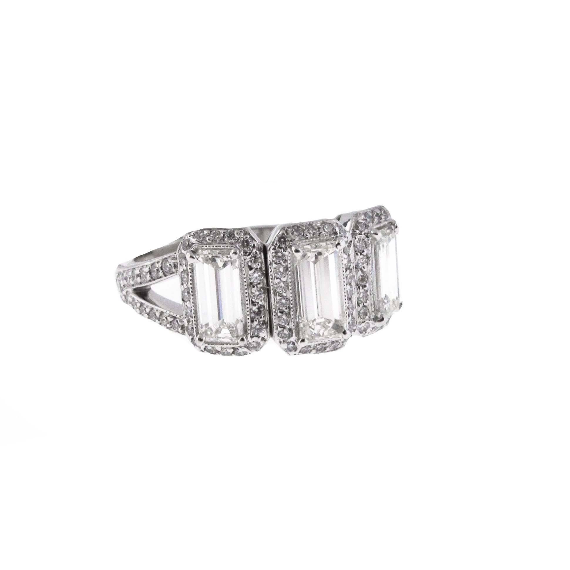 Fantastic look that can be worn as an engagement ring or as a fashion ring. 3 white and clean emerald cut diamonds set among an array of round brilliant diamonds. Each emerald cut is approximately .60 carats for a total of almost 1.80 carats. This