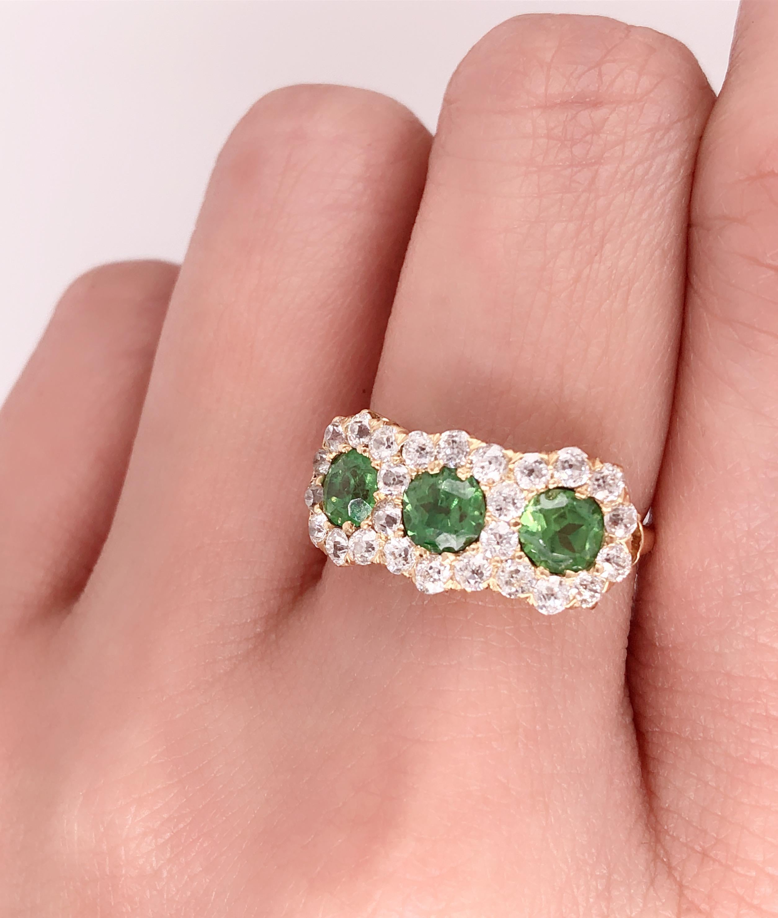 Three Stone Emerald & Diamond Modern Ring. . Housing approx. Three sixty point round emerald stones for a total of 1.8 ct. each flanked by a total group of 25 round diamonds approx .05 diamonds for a total 1.25 ct of diamonds. Ring Size