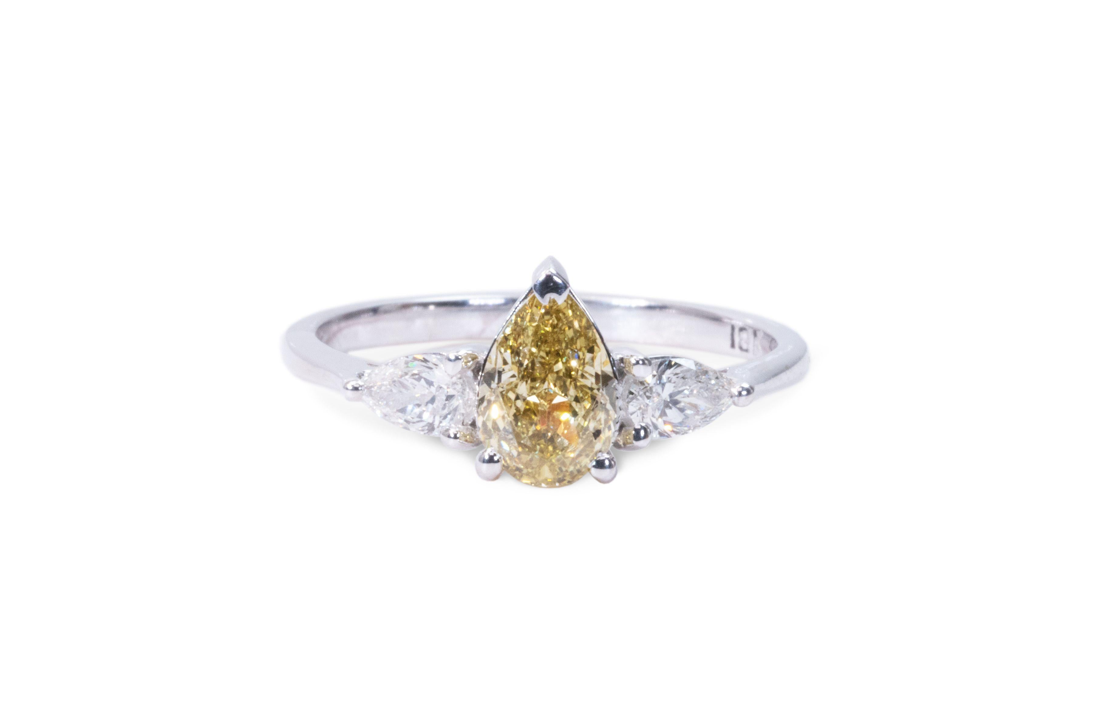 Stunning 3 stone ring made from 18k white gold with 1.22 total diamond carats of pear shape diamonds. This ring comes with a GIA certificate and a fancy box.

-1 diamond main stone of 0.91 ct.
cut: pear
color: natural fancy brownish yellow
clarity: