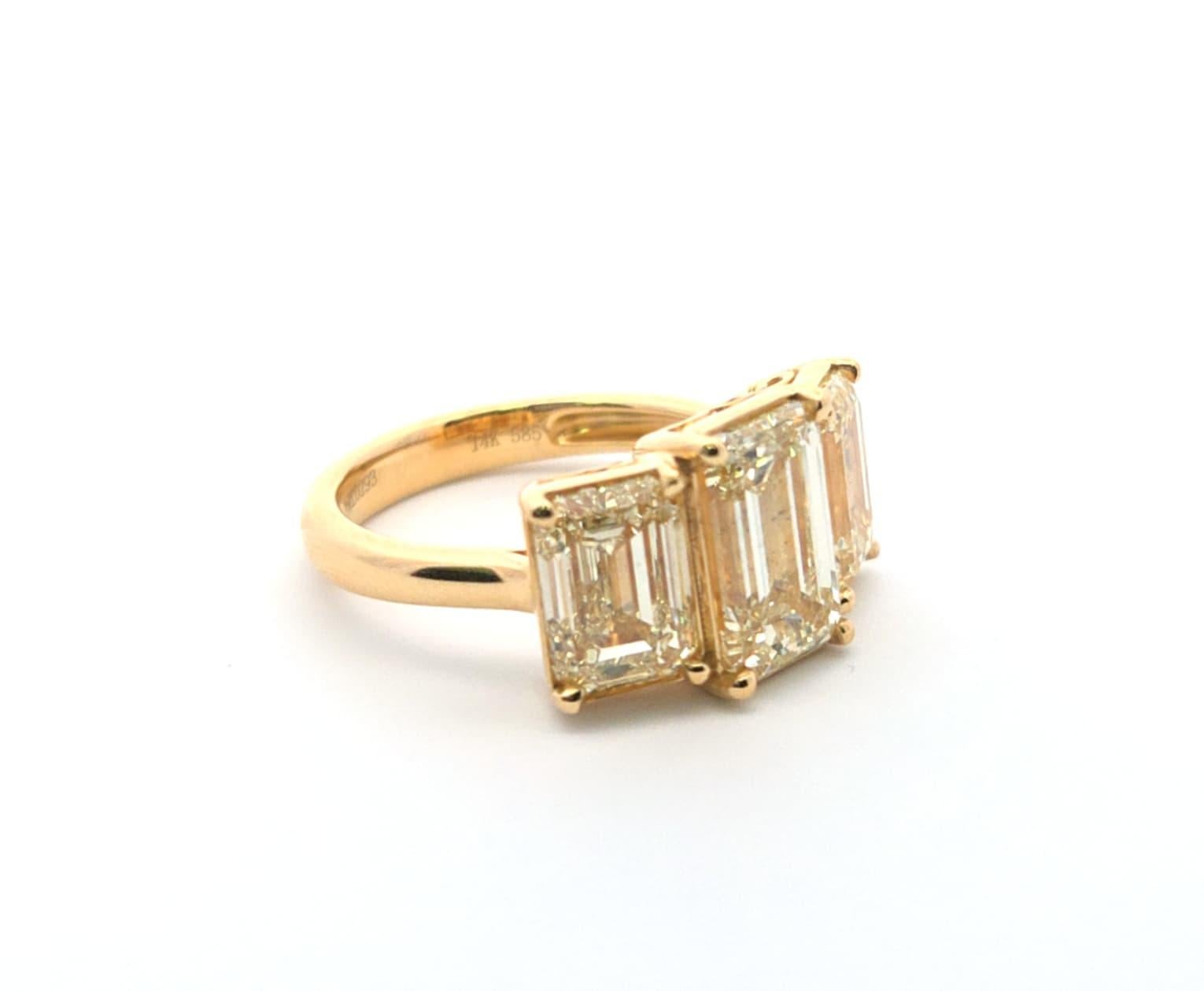 Dieser atemberaubende Ring mit drei Steinen im Smaragdschliff verkörpert das Wesen zeitloser Eleganz. Der längliche zentrale Edelstein, der von den beiden passenden Seitensteinen eingerahmt wird, bildet einen auffälligen Kontrast, der jedes Outfit