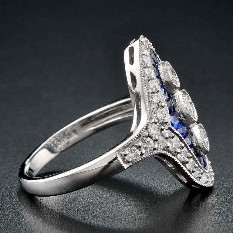 Glimmering with diamonds and drama, this vintage-inspired Art Deco style ring will have heads turning. Crafted in platinum, this shimmering look features three round diamonds wrapped in French cut sapphire and diamond-lined halo frames create a