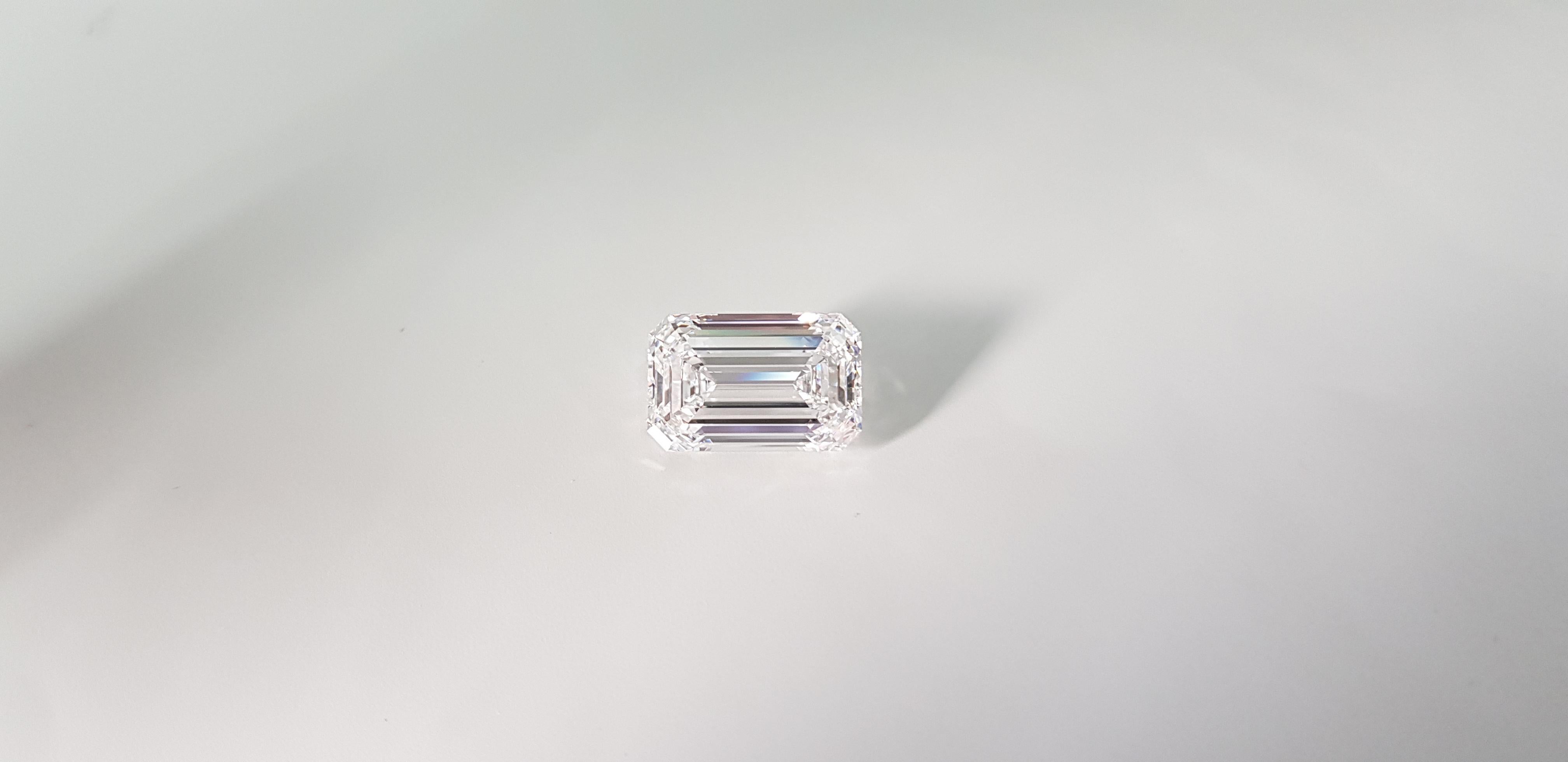 This exquisite ring features a majestic GIA certified emerald cut diamond weighing 5 carats. The main diamond, with its emerald cut that exudes elegance and geometric purity, is set between two trapezoid diamonds, accentuating its unparalleled