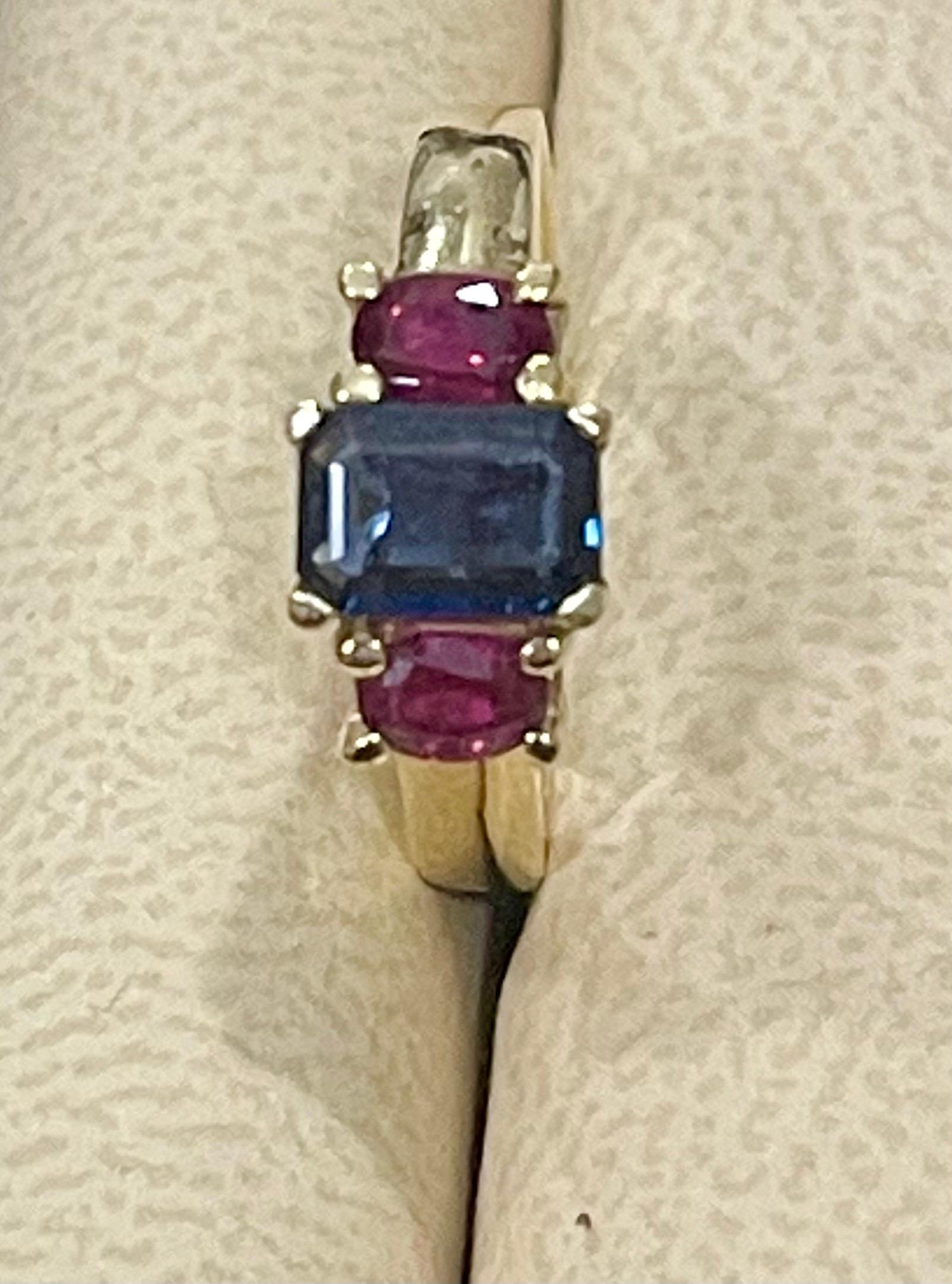 Three Stone Natural Blue Sapphire & Ruby Engagement Ring in 14 Karat Yellow Gold
Approximately 1  Ct Emerald cut Blue Sapphire 
and two rubies weighing approximately 0.5 ct

14 Karat yellow Gold 4.8 Grams
Ring Size 5 & 1/2 ( it can be resized to any