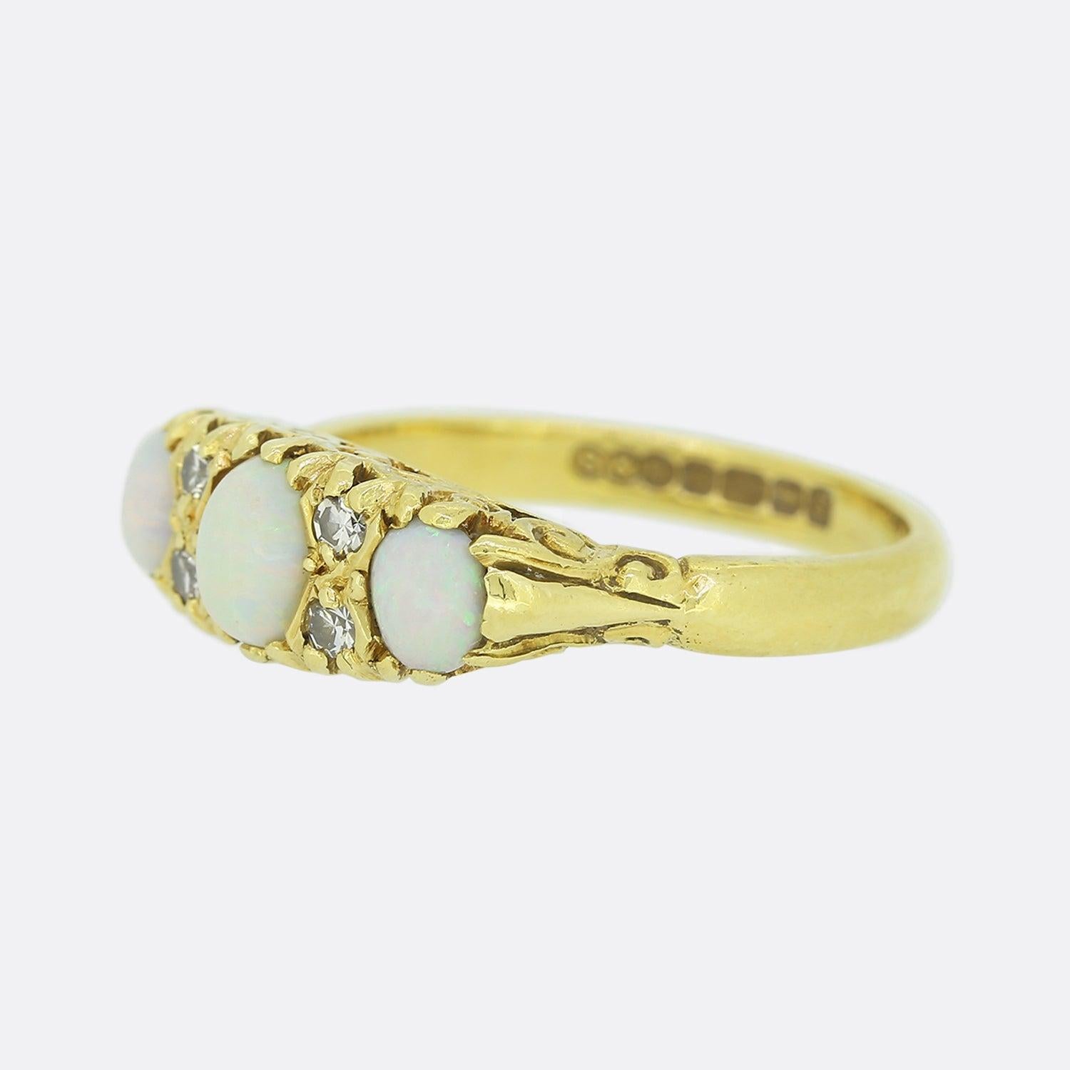 This is an 18ct yellow gold opal and diamond ring. The ring is set with three graduated oval cut cabochon opals that each have a vibrant and wonderful play of colour. There is also four small single cut diamonds set in between the opals.

Condition:
