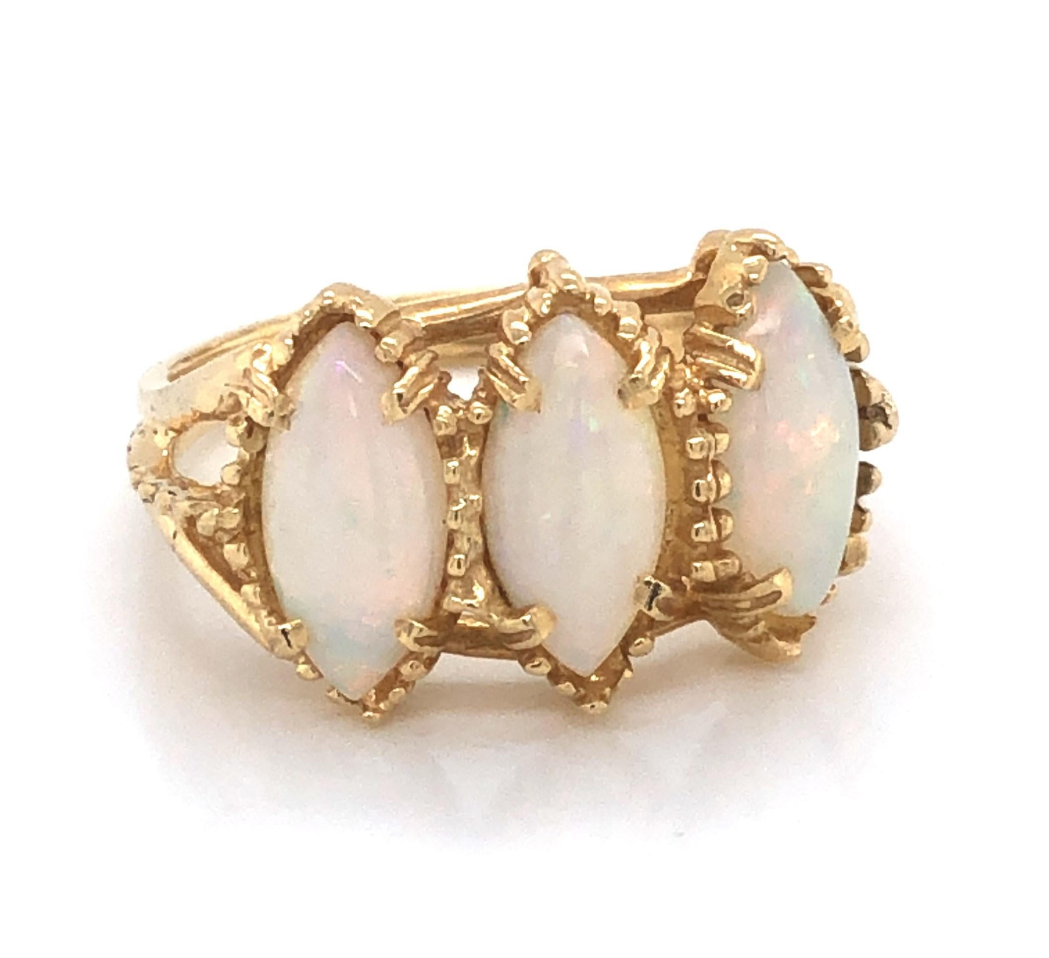 Naturally romantic, a trio of marquise cut iridescent opal cabochons certainly draw attention to this lovely antique style ring created in fourteen karat 14k yellow gold.
The decorative split shank leads to a beautiful presentation of three .50