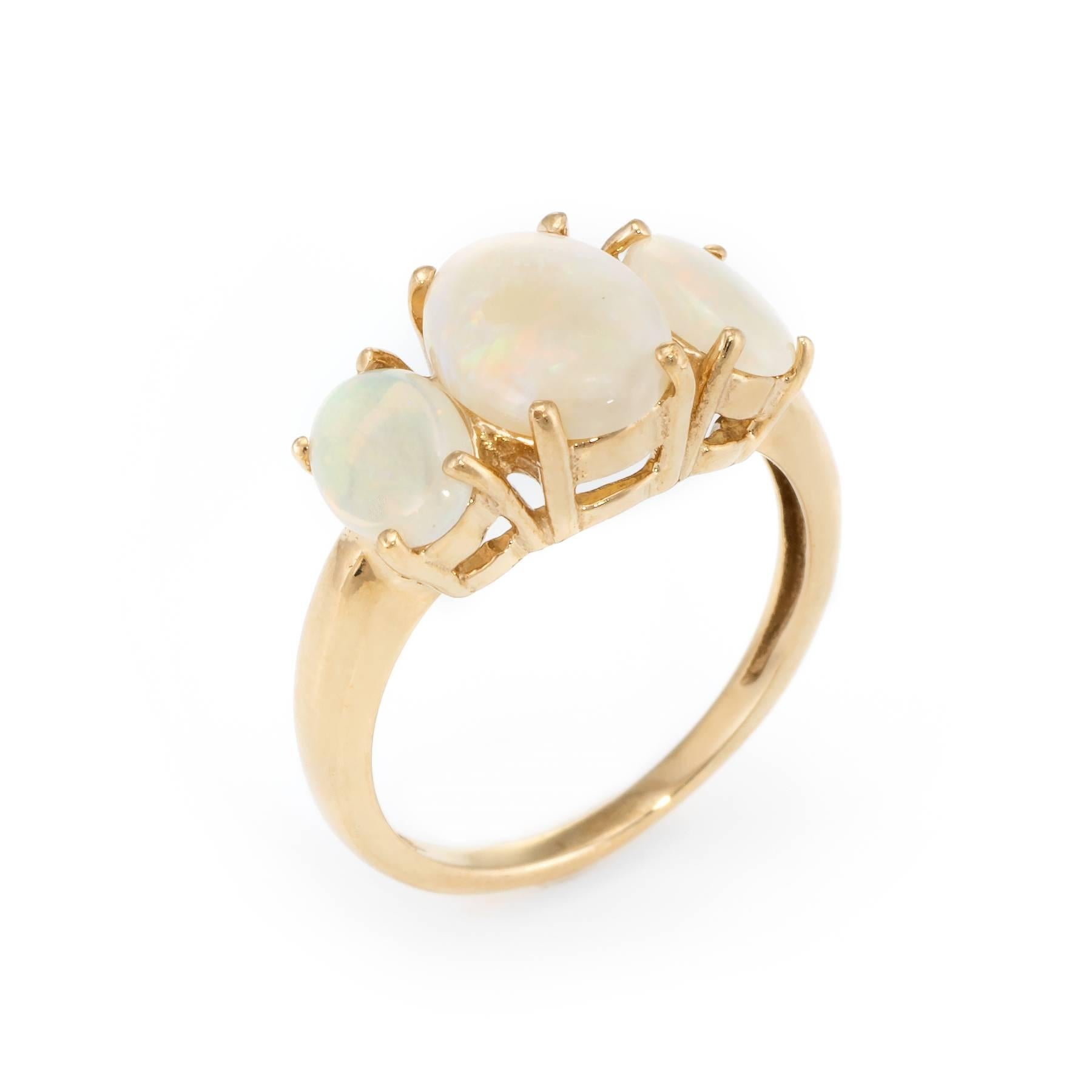 Elegant vintage 3 stone opal ring, crafted in 10 karat yellow gold. 

Oval cut opals range in size from 7mm x 5mm (outer - estimated at 1.50 carats) 9mm x 7mm (center - estimated at 2 carats). The total opal weight is estimated at 3.50 carats. The