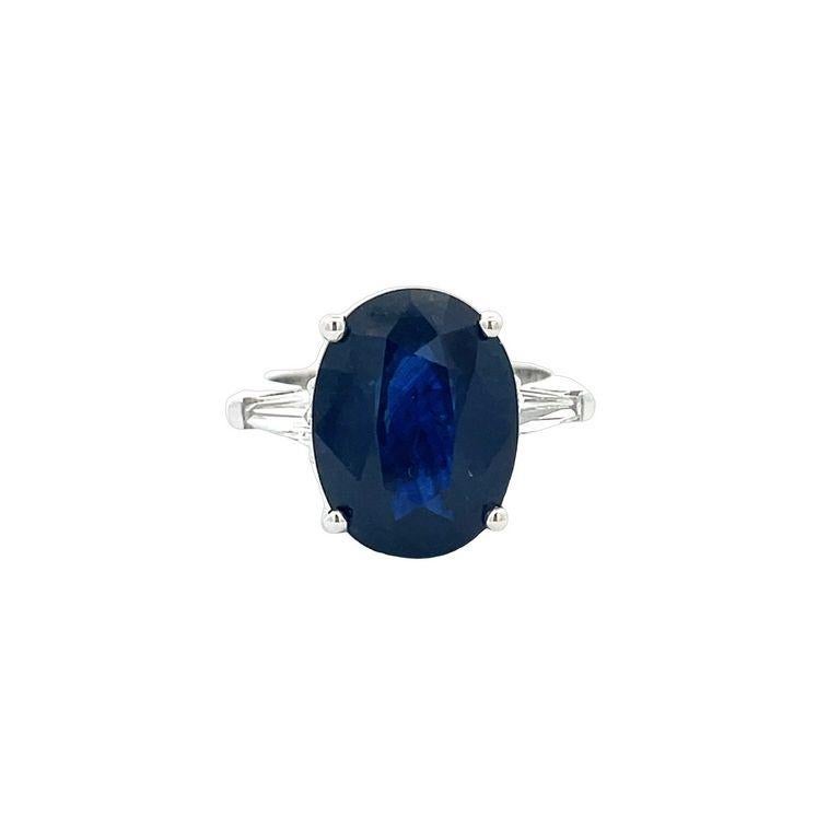 Get ready to be blown away by the breathtaking beauty of this three-stone ring! Featuring a stunning oval-shaped blue sapphire in the finest color for this gemstone, this ring boasts a center stone weighing an impressive 8.35 carats. Accompanying
