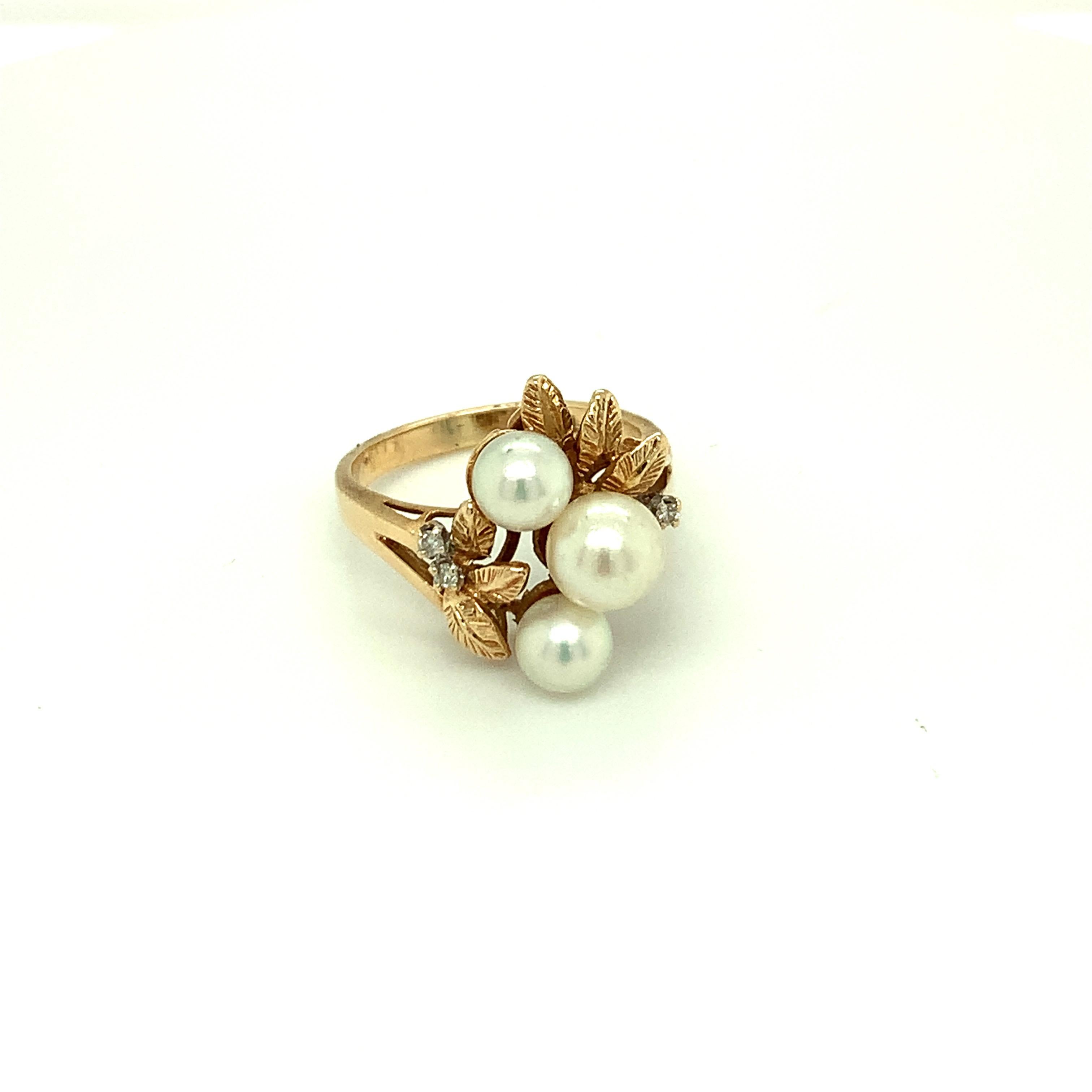 This graceful three stone style pearl ring displays a trio of luminous cultured pearls with accents of diamonds and leaf motifs. Set in 14K yellow gold is a beautiful gift for a June born.