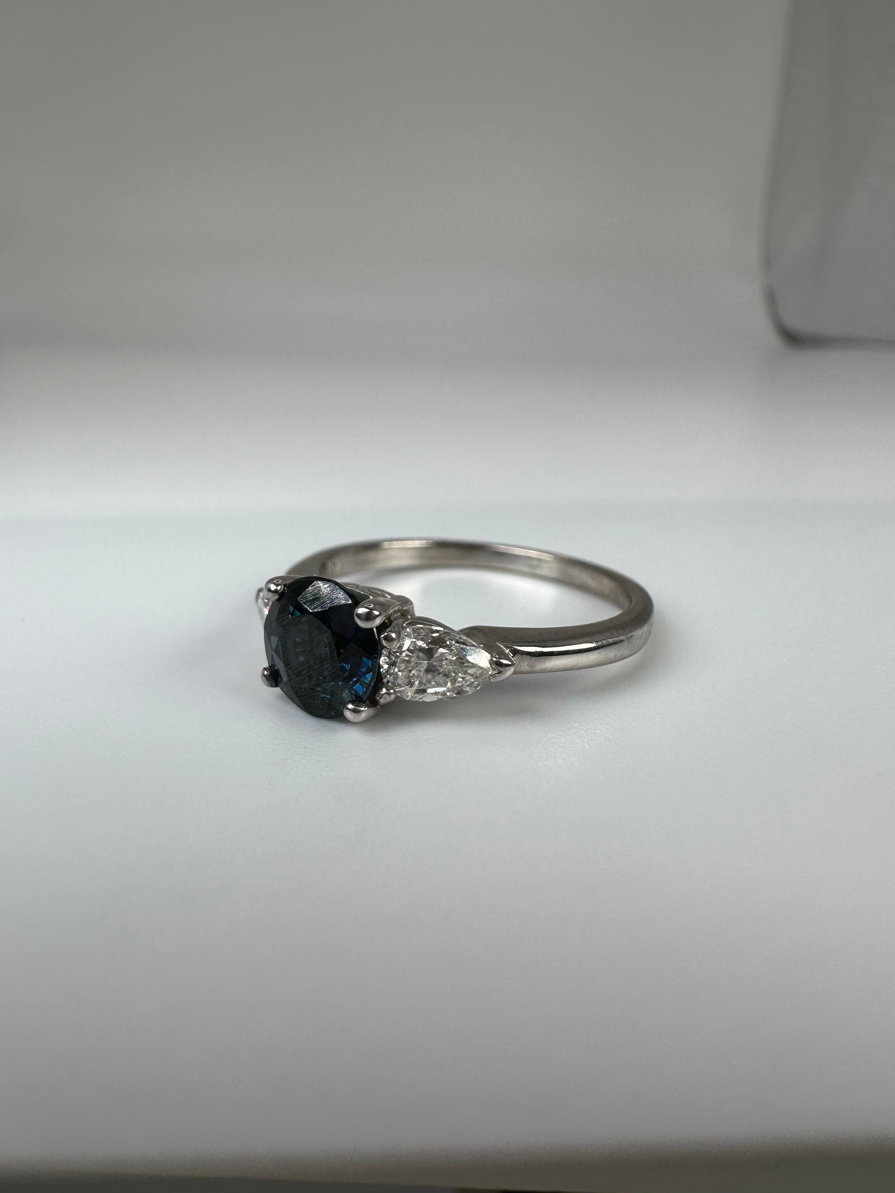 Three stone diamond ring made with sapphire and two stunning pear shape diamonds, the ring is a classical beauty. The diamonds are fantastic quality with lots of sparkle, the sapphire has a bit of a greenish undertone. This ring is modern with a
