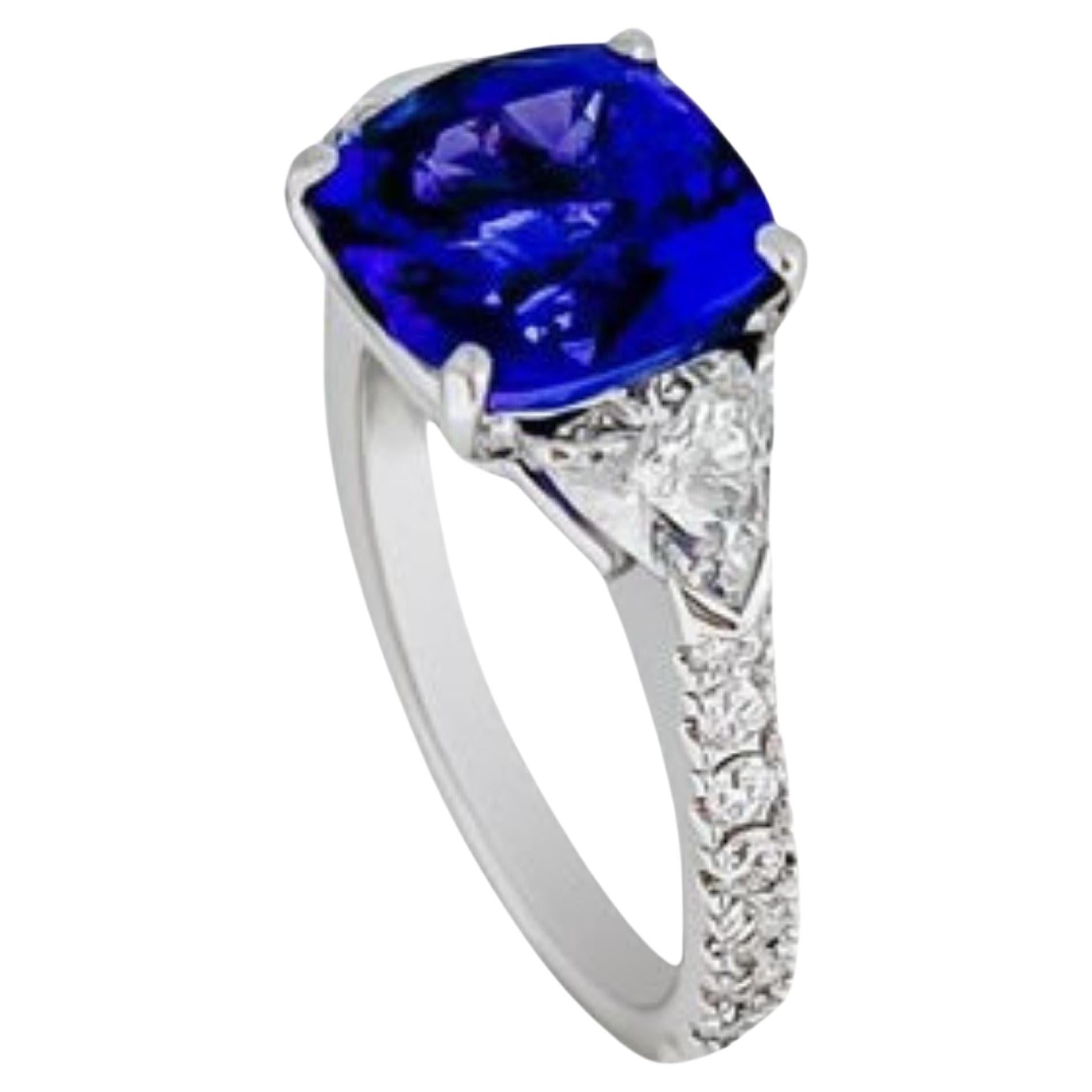 This stunning three stone ring has a 3.62ct tanzanite center stone, surrounded by half carat trillion cut diamonds in G VS1 quality. The band is set with G colored diamonds in 18k white gold. Truly a beautiful gemstone and ring. 

The ring is in a