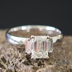 Anello a tre pietre con diamante taglio smeraldo e diamanti laterali a baguette affusolati