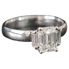 Anillo de tres piedras con diamante talla esmeralda y diamantes laterales baguette cónicos