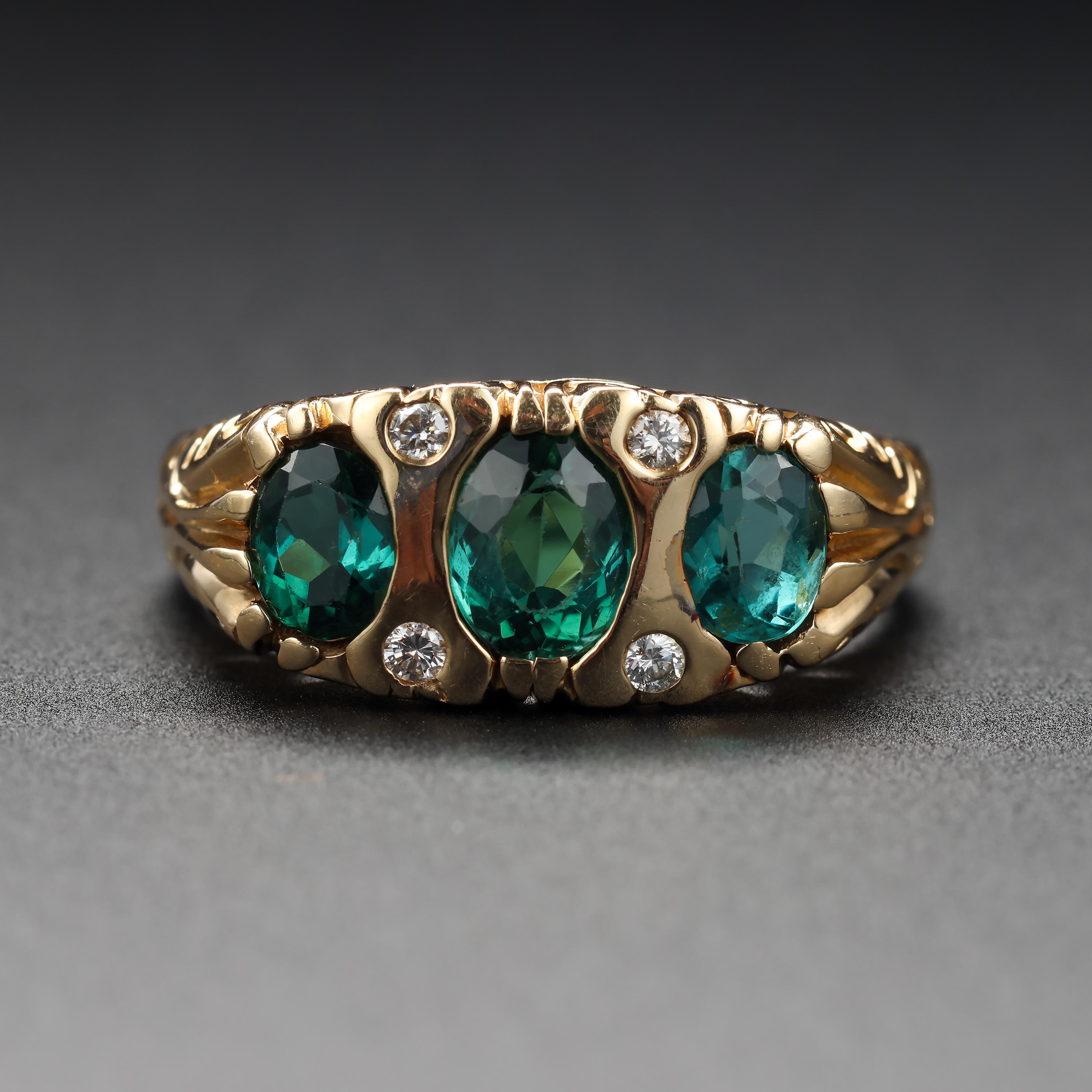 This handsome, classic three-stone tourmaline ring has lovely scrollwork on the face and shoulders but its Victorian good looks are vintage rather than antique, as the ring dates to the latter part of the previous century -circa 1980s, 1990s.