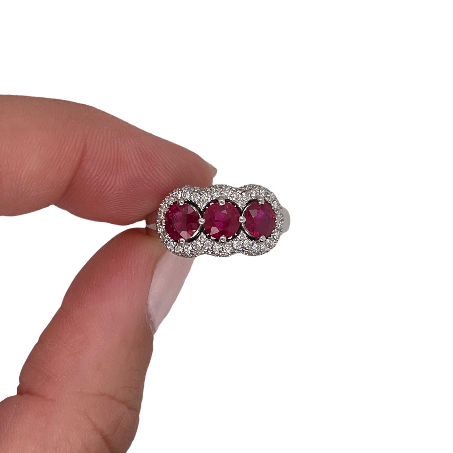 Ring contains 3 round brilliant rubies, 1.65tcw and 66 round brilliant diamonds, 0.50tcw. Diamonds are G in color and VS1 in clarity, excellent cut. All stones are mounted in 18k white gold prong settings. Ring is a size 6 and can be resized to