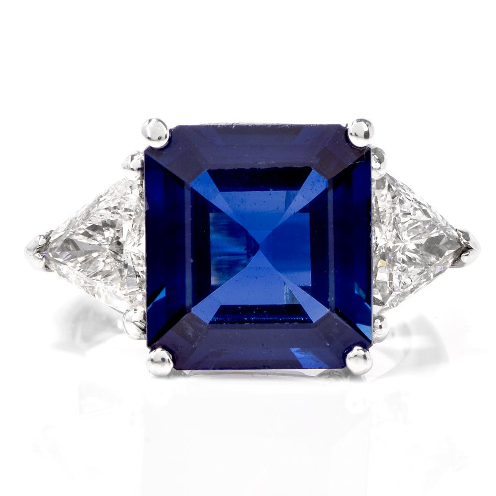 This sophisticated estate three stone sapphire and diamond ring is crafted in solid platinum. Exposing a centered GIA certified heated genuine natural corundum emerald cut sapphire weighing approx. 5.53 carats. In between two trilliant-cut diamonds