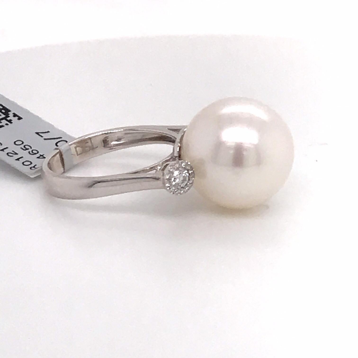 18K White gold three stone ring featuring one South Sea Pearl center measuring 14-15 MM flanked with 26 round diamonds weighing 0.12 carats. 

Measurements:
South Sea Pearl: 14-15 MM
Diamond Circle: 4.36 MM
Height On Finger: 15.4 MM

Ring can be