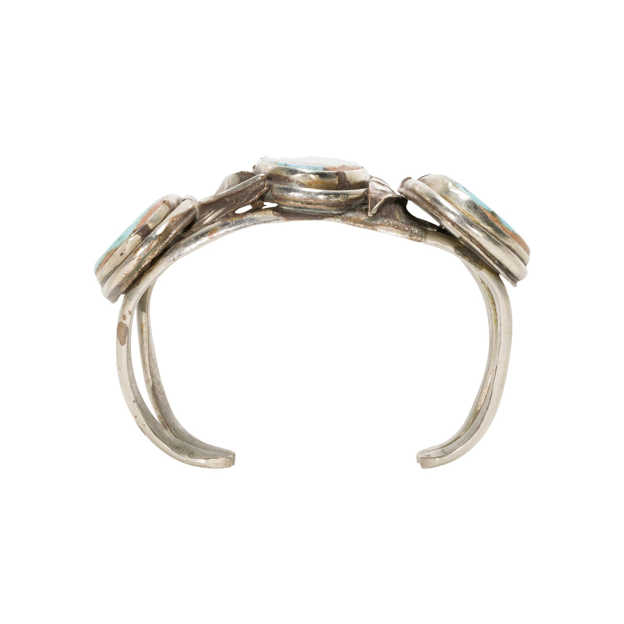 Bracciale a tre pietre di turchese e argento sterling. Le pietre hanno un taglio asimmetrico e sono incastonate in un semplice castone. Splendido colore blu brillante con matrice marrone, oro e nera. Attaccato a un semplice bracciale a doppia fascia