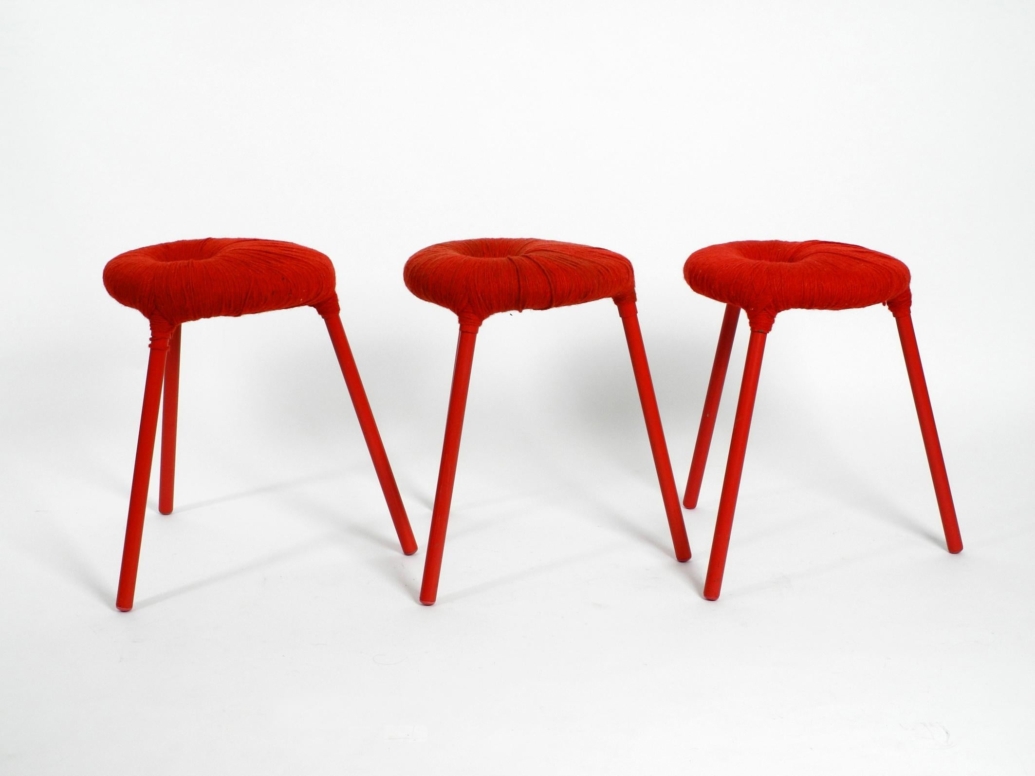 Three very rare three-legged stools model Eskilstuna. 
From the Ikea PS series from 1999.
Design by Findlay, Graeme, McElroy and Carmen. 
Wanted classics, were built only briefly.
Tubular steel legs, metal frame wrapped in red wool.
All three