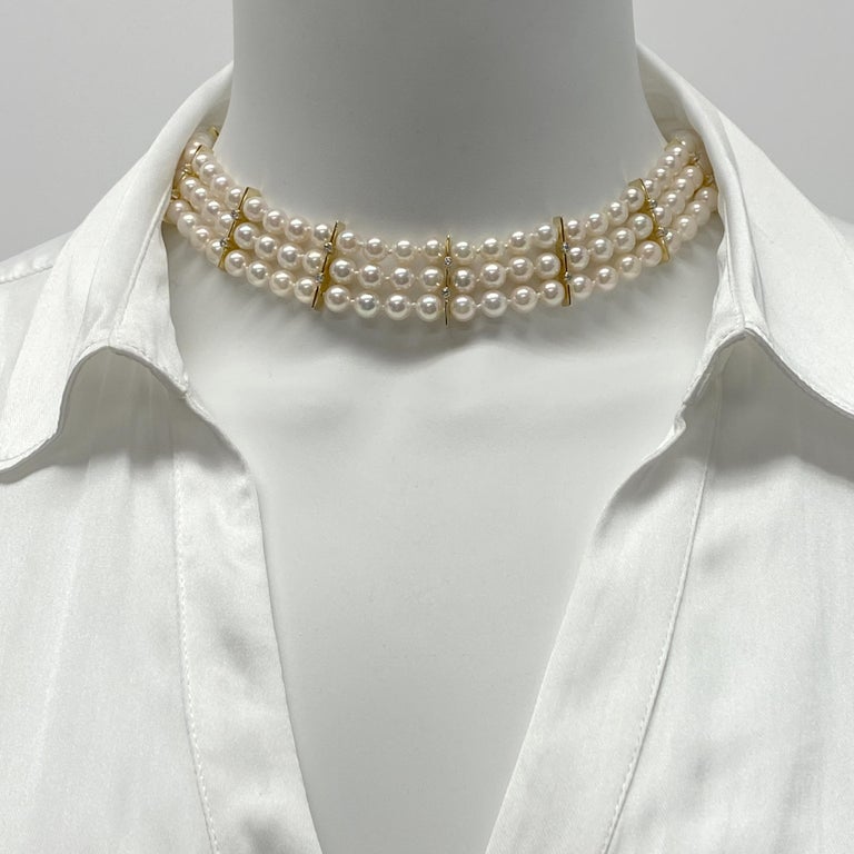 This is a custom-made necklace by Lawrence Poon of Seattle, produced in 1992.    It features three rows of 6mm - 6.5mm Akoya cultured pearls.  Eight separator plates of 18 karat yellow gold are spaced evenly along the front of the necklace, and the