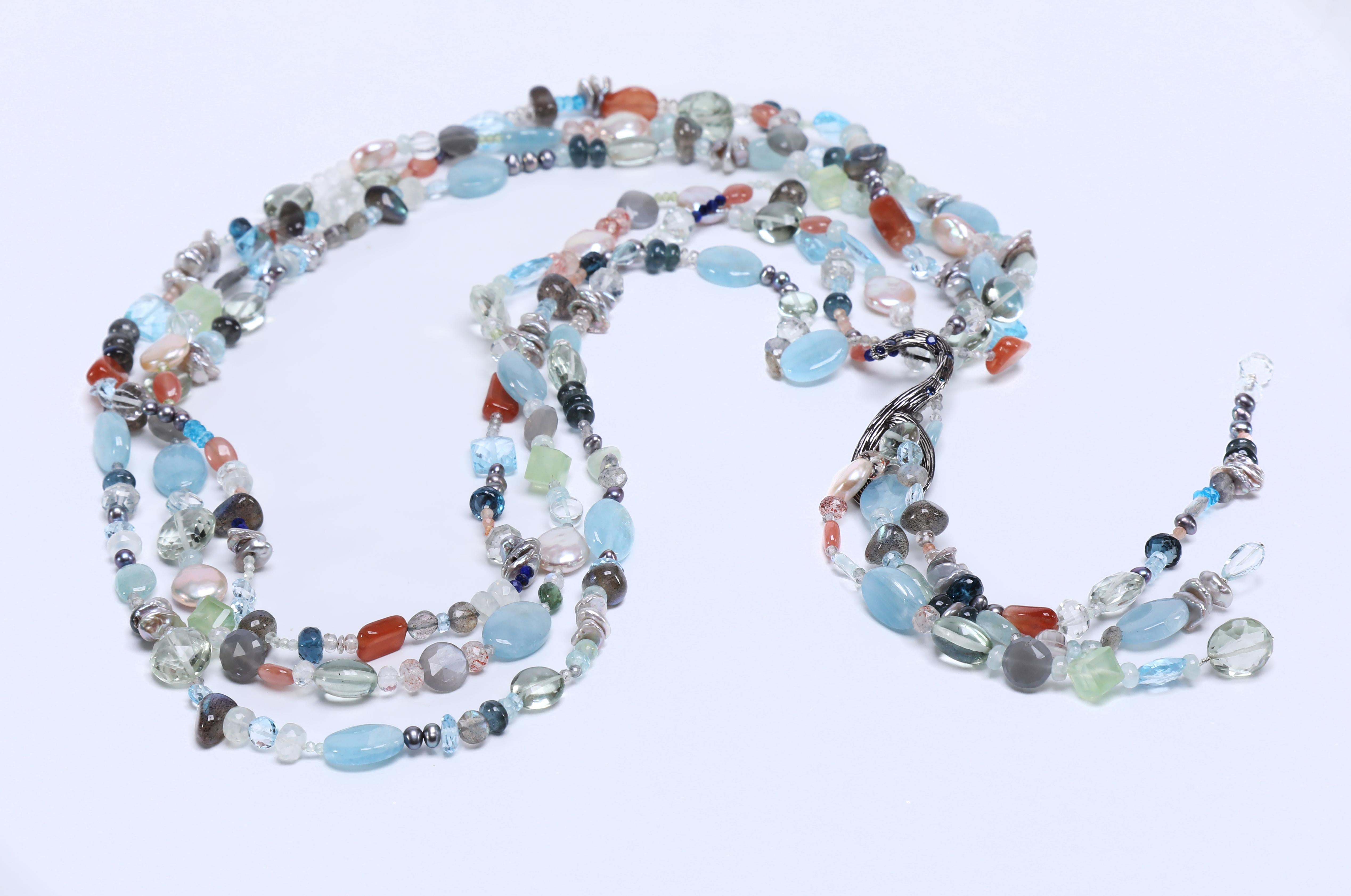 Who creates a necklace of blue topaz, moonstone, aquamarine, apatite, sapphire and silver?  White Orchid Studio does.  The lariat is 